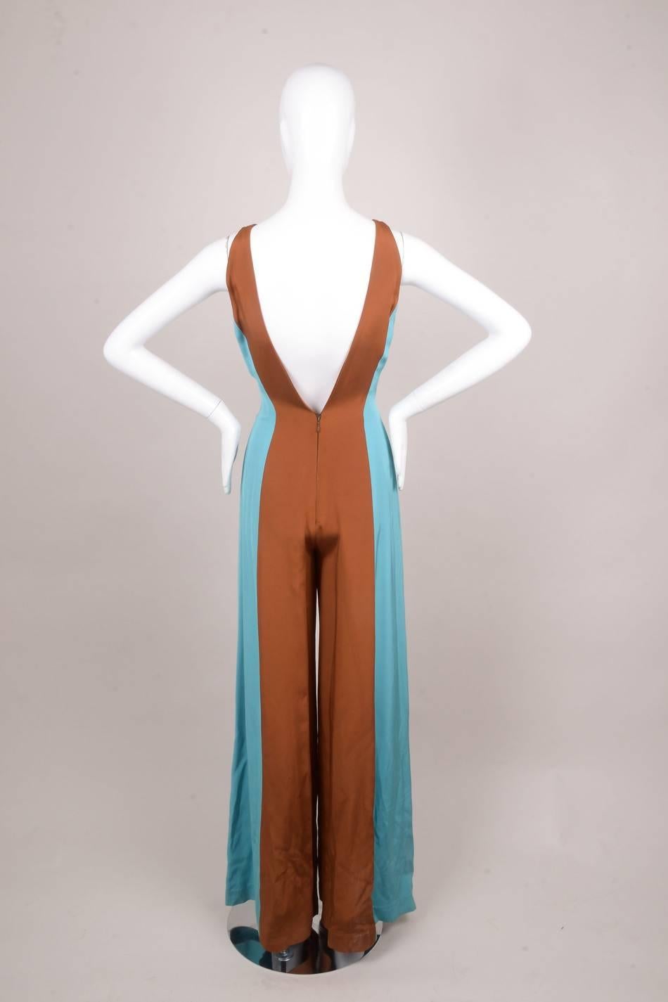 Fun and flirty vintage Lorenzo Riva couture blue/brown color block sleeveless silk jumpsuit. Vertical blue and brown color blocking throughout. Plunging double v-neckline. Sleeveless. Wide, flared leg. Back zip fastening. 

Additional