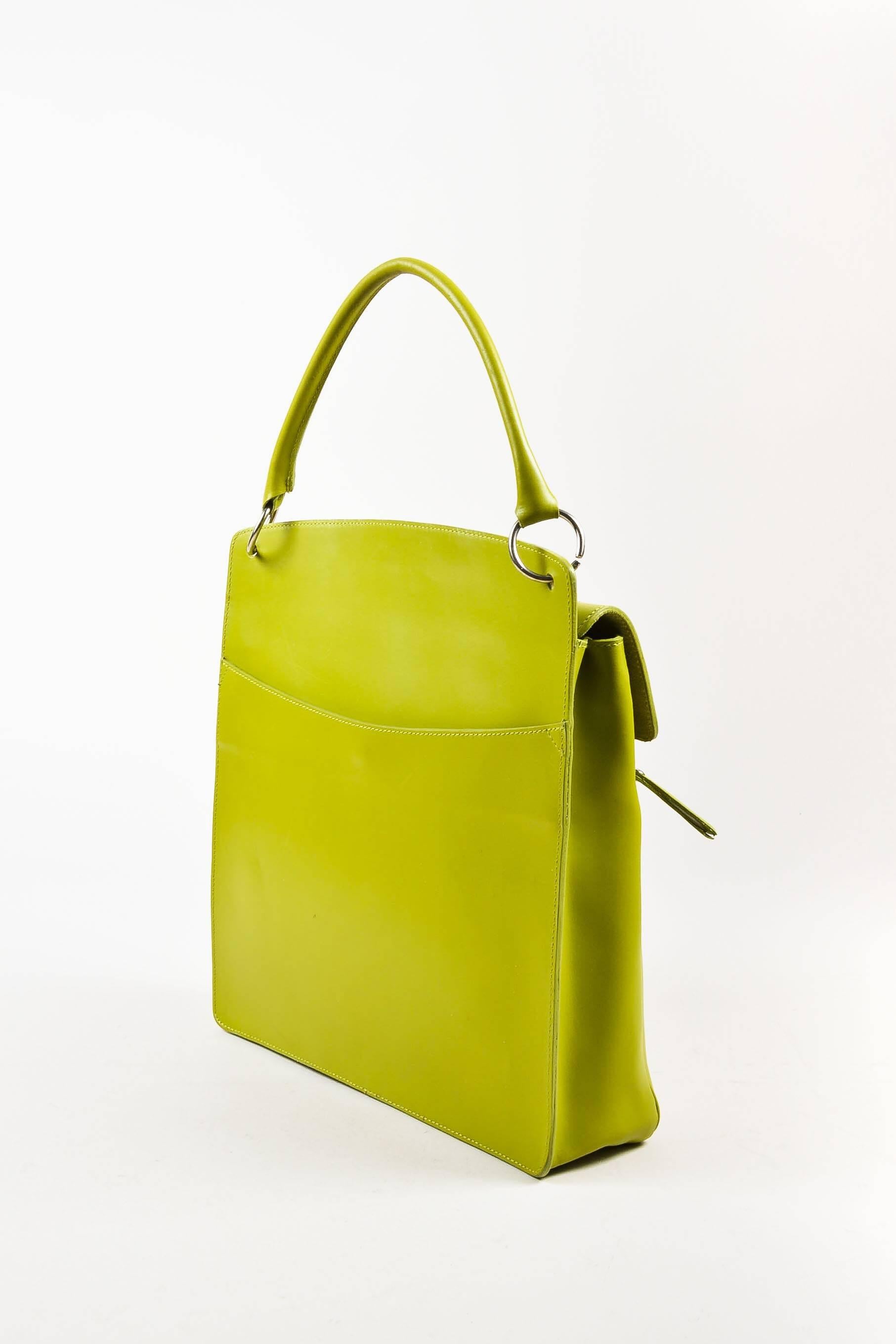 Vintage bag in a lighthearted hue featuring a single rolled top handle with golden metallic O-rings, a front flap with an enameled twist-lock closure, a front zipped pocket, and a snapped back pocket. Tonal stitching & piping. Flat
