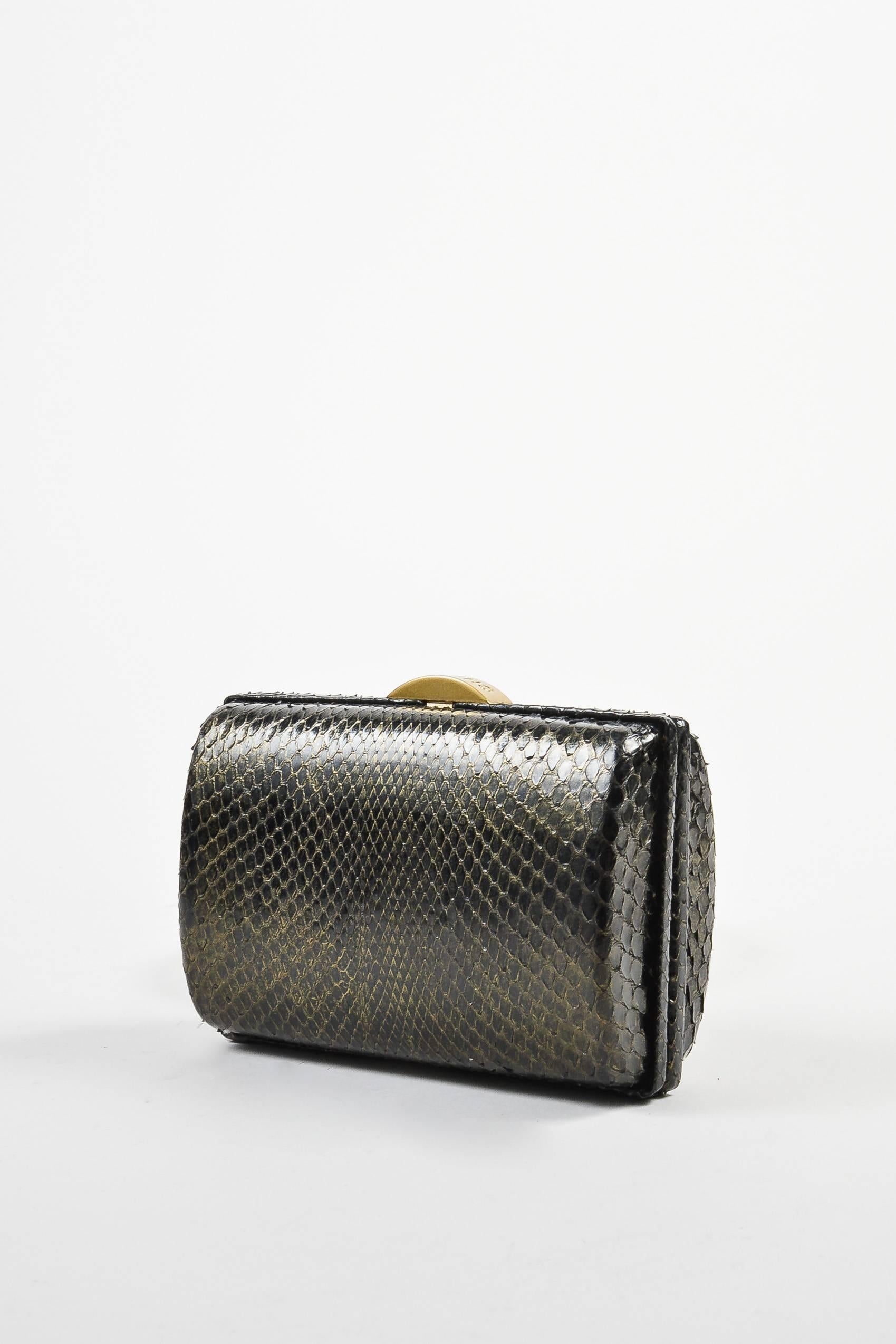 Dainty and luxurious box clutch by Chanel. Black python exterior with a gold-tone closure. The perfect choice for a cocktail hour or a night on the town. Small size will hold only the essentials. Frame design hinges open. Lined in metallic gold-tone