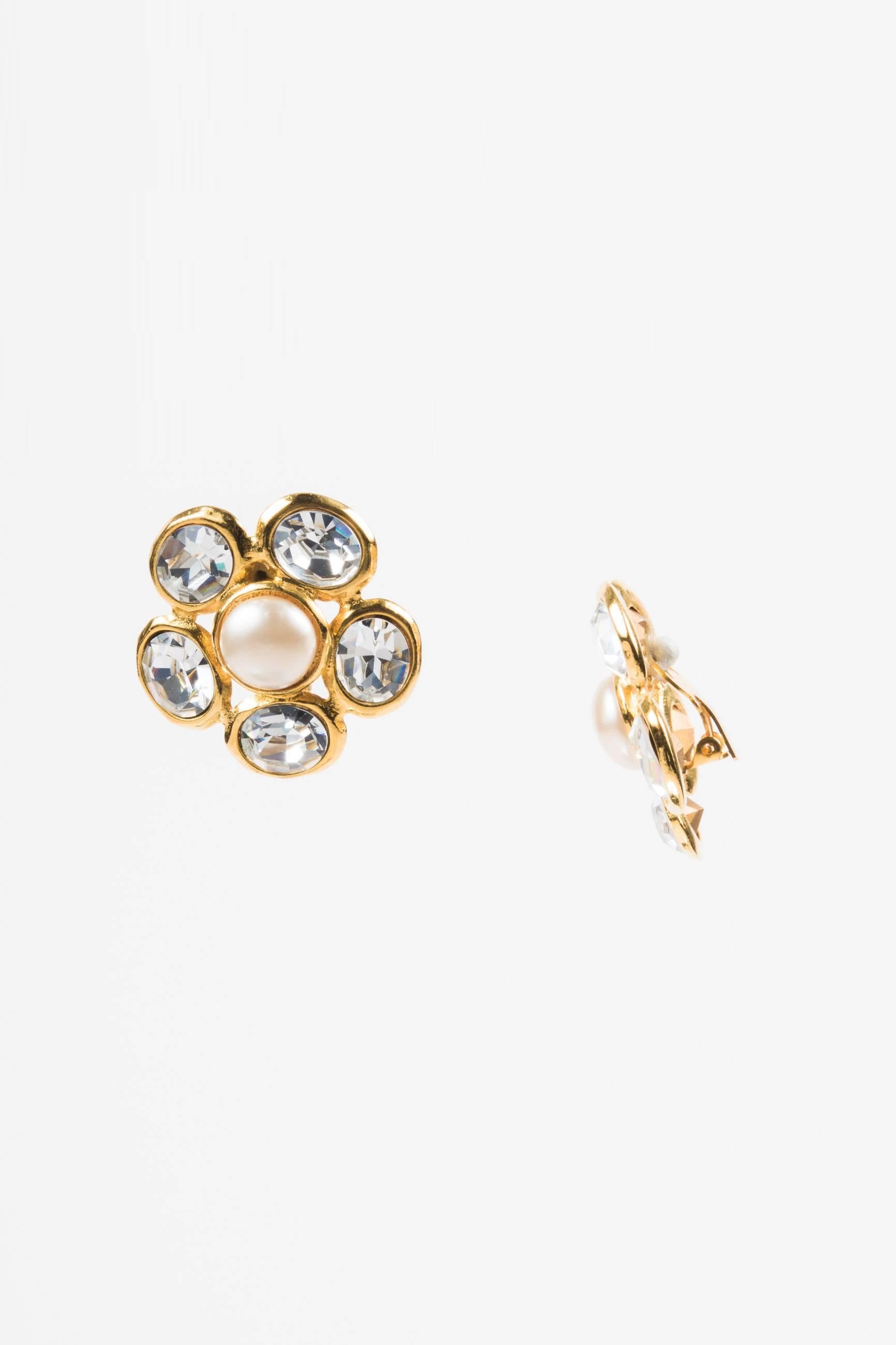 Vintage gold-tone metal cluster earrings by Chanel. Features a faux pearl center surrounded by large clear crystals. Clip ons. Season 29. Circa 1992.