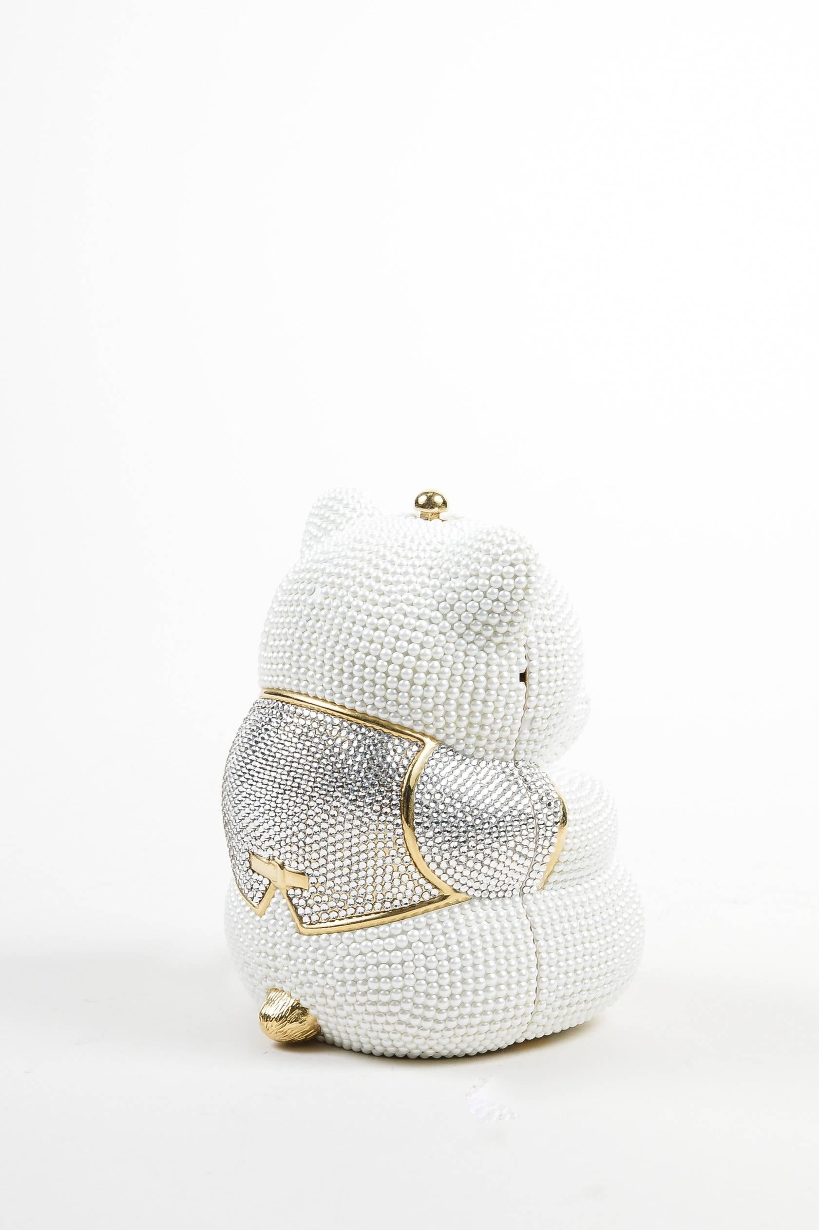 Retails at $4695. This whimsical Judith Leiber Wedding minaudiere is shaped like a glittering teddy bear. White faux pearls and clear rhinestones with gold-tone metallic accents. This small clutch bag is the perfect conversation piece for your next