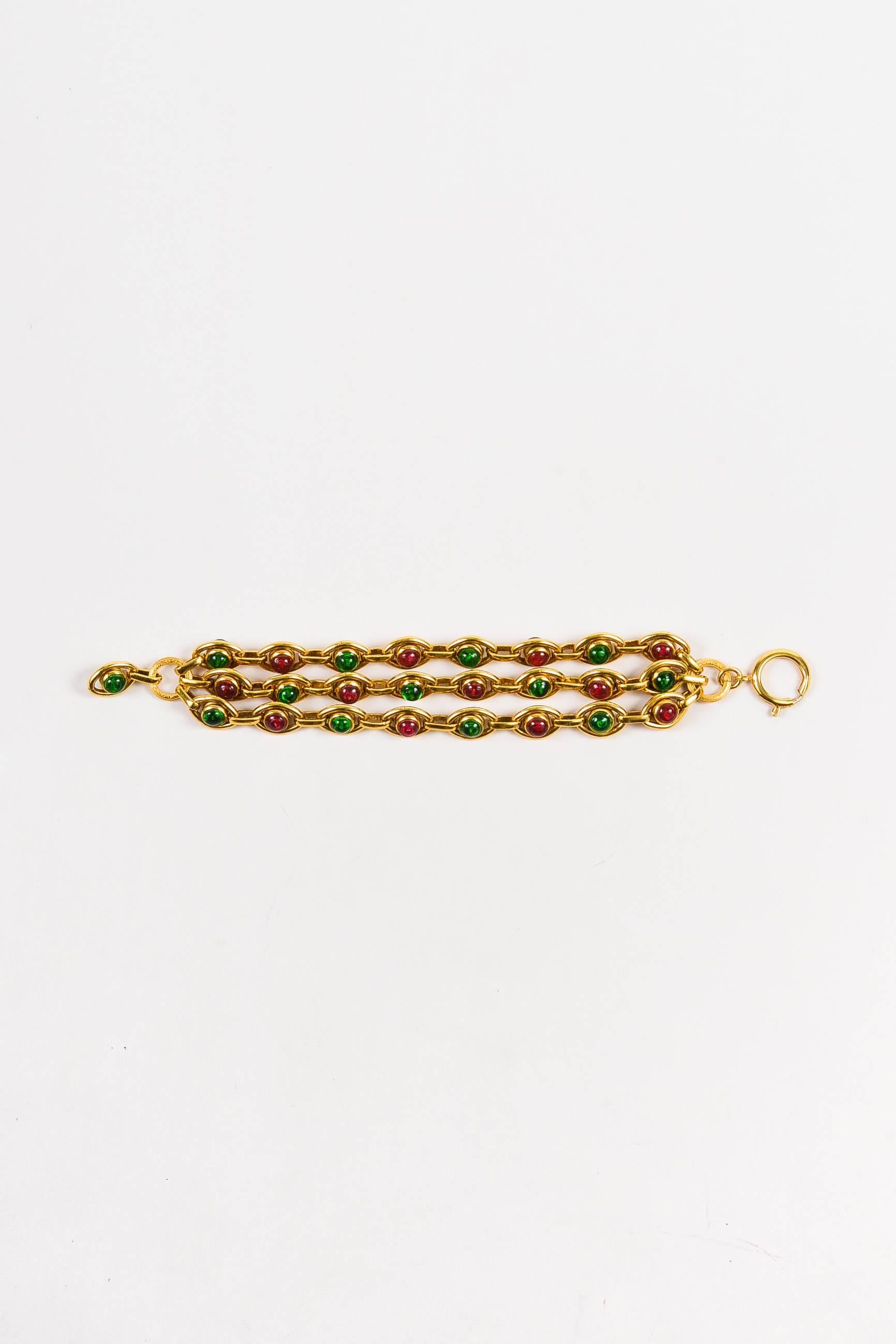 Intricate statement bracelet that exudes vintage Chanel sophistication. Gold-tone hardware. Multi-strand link chain. Bold pink and green Gripoix glass embellishment. Spring clasp closure.

Condition:
Pre-owned. Some signs of wear and tear. Brand