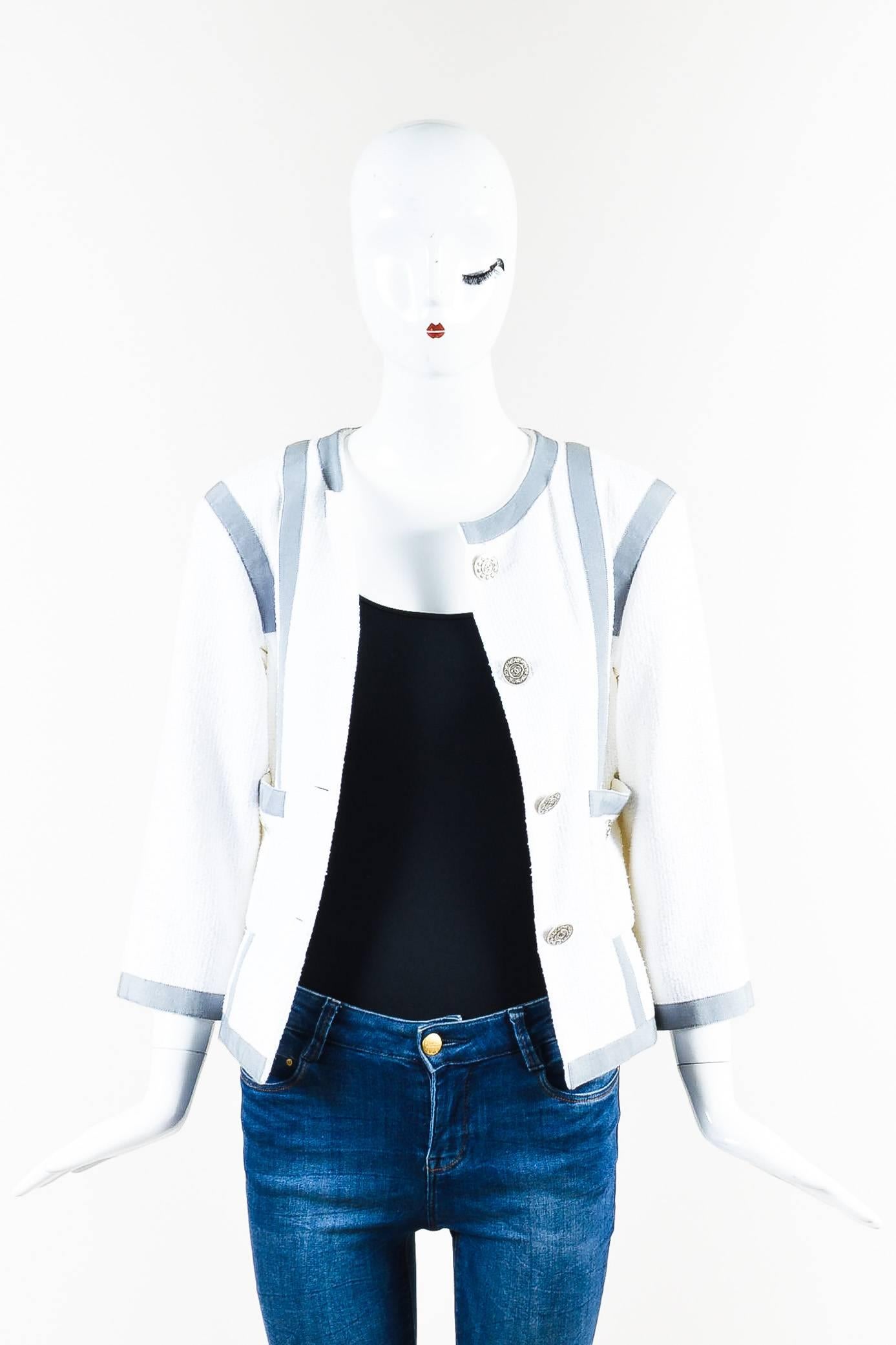 The signature style lady jacket from the house of Chanel gets an update with this piece featuring contrasting grosgrain trimming, structured shoulders, a collarless neckline, cropped sleeves, dual front patch pockets, and starred 'CC' buttons down