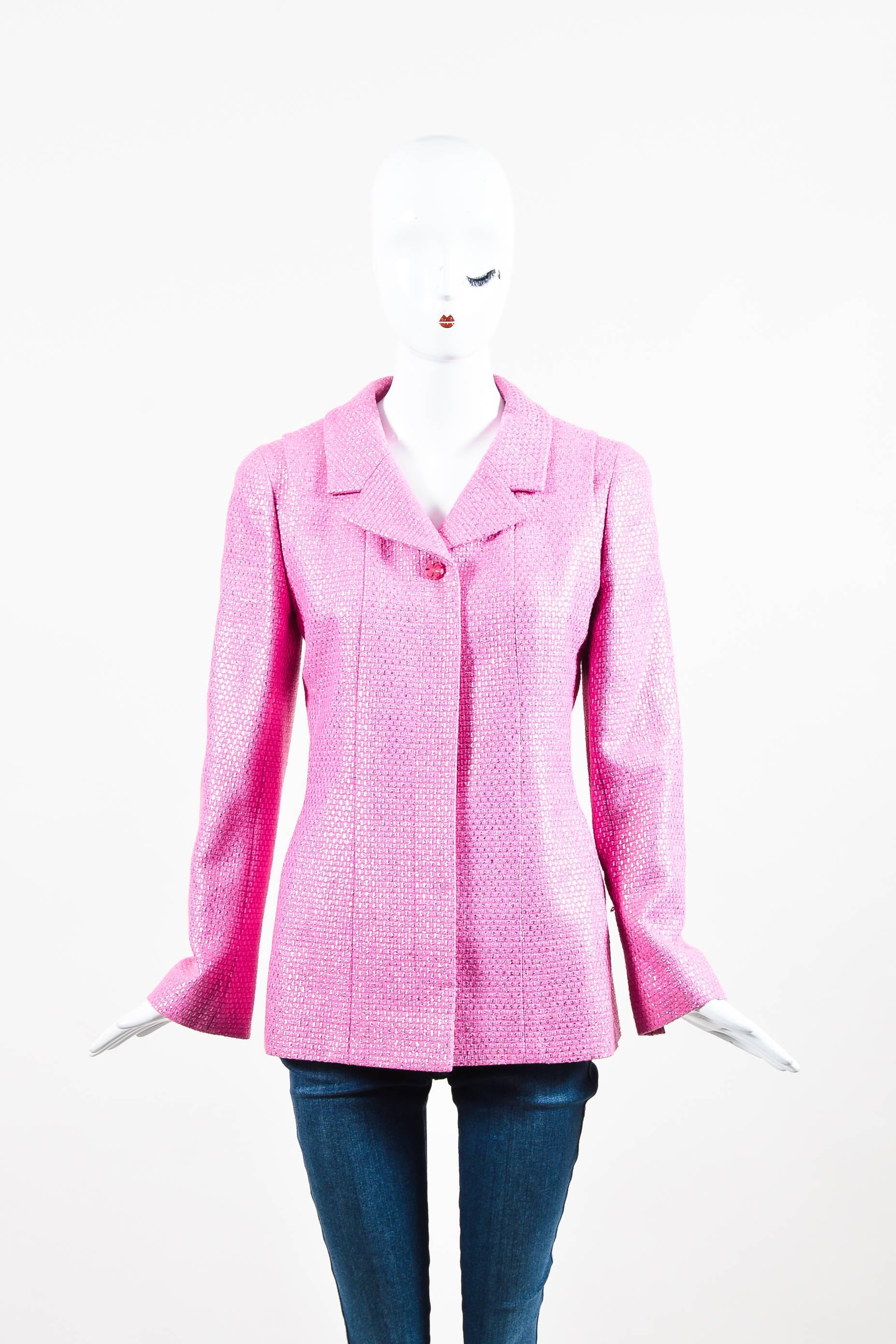 Bubblegum pink long sleeve buttoned jacket from Chanel features metallic square woven details throughout. Hidden buttons down the front for closure. The first button is made of clear plastic with a printed four leaf clover. This button is the only