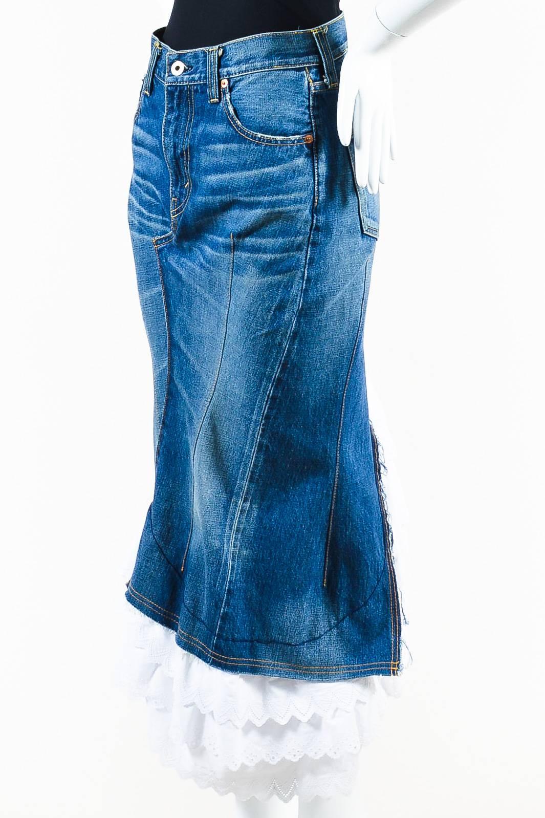 Junya Watanabe Comme des Garcons blue denim skirt featuring layered white scalloped ruffles at hem and five pocket design with zip fly closure. Golden yellow topstitching throughout. Trumpet silhouette. Unlined.