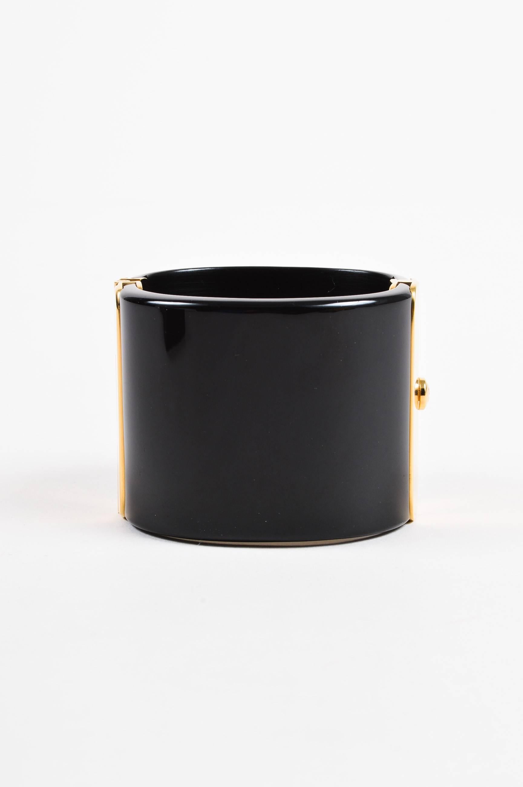Comes with box and dust bag. Bold statement cuff from Fall 2011 Collection. Black resin wide bangle with ornate gold-tone metal embellished with glittery black and dark red gripoix stones. Ridged 'CC' logo at center stone. Oval opening. Push lock