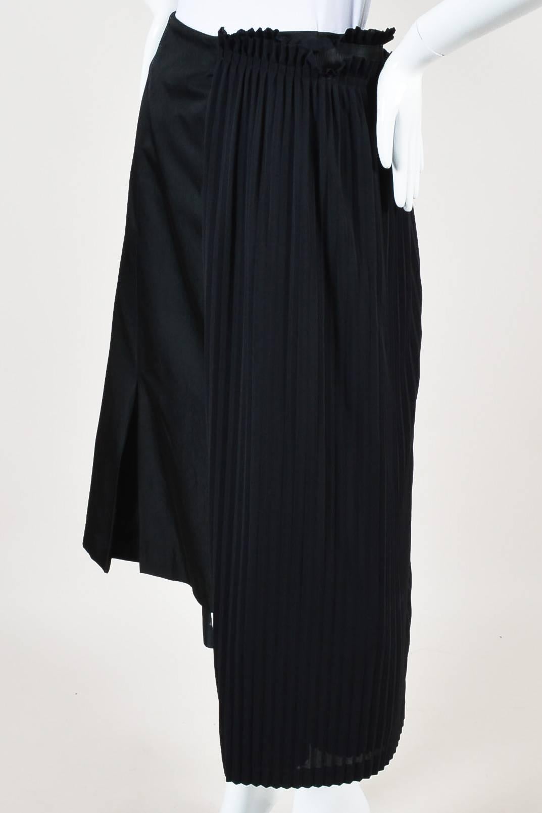 Avant-garde skirt features an attached pleated panel and extra skirt layer at the side with asymmetrical waistline and hem. Two zip and two hook-and-eye closures.