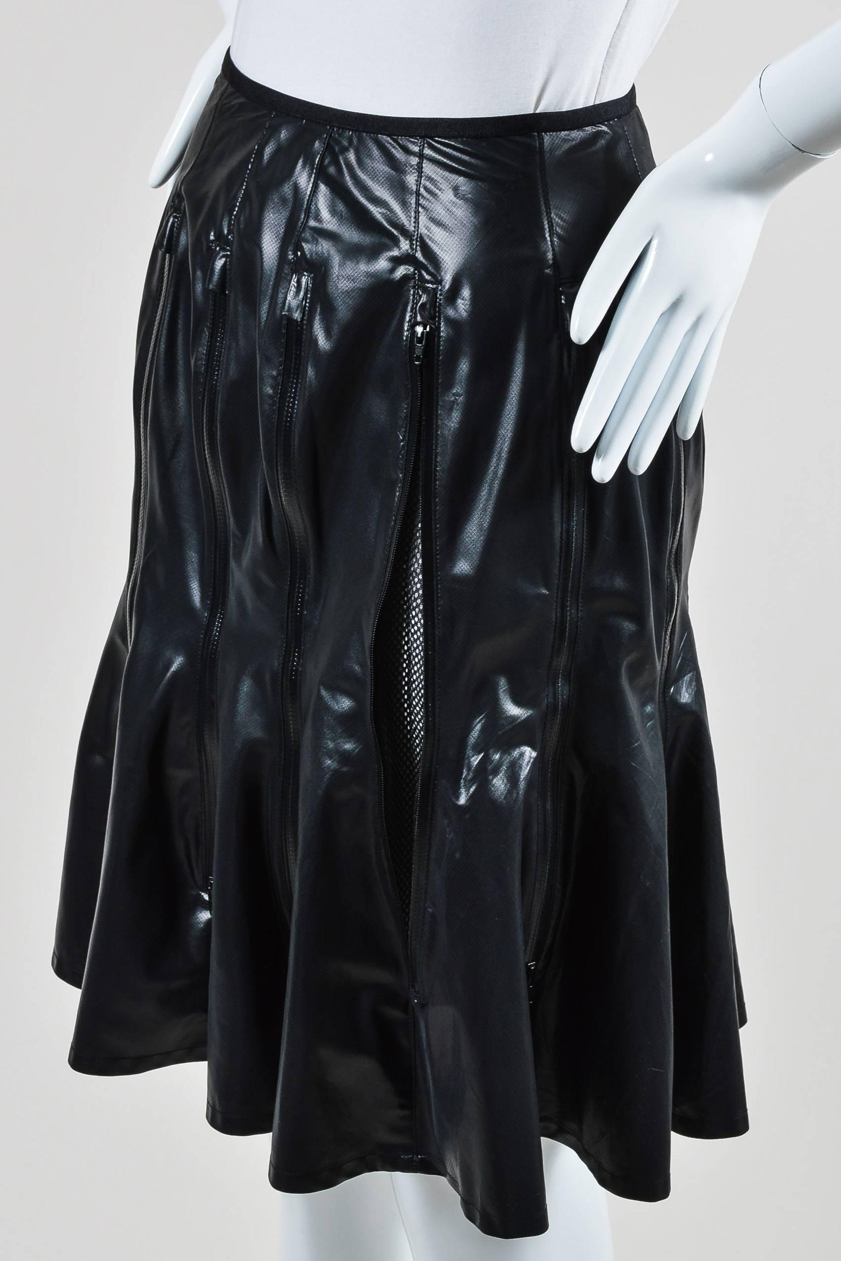 Knee length flare skirt. This avant-garde skirt features vertical zipper details with inner mesh paneling, glossy fabric, and flare at hem. Hook-and-eye and hidden zipper closure in back.