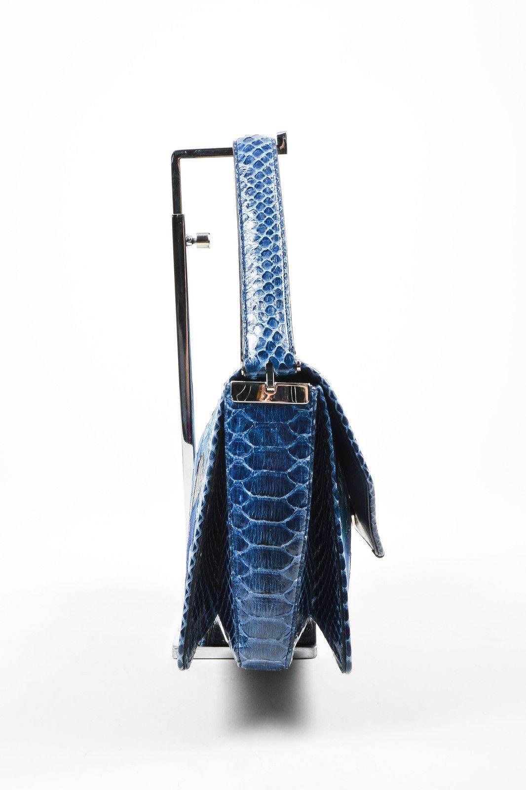 Mixed media handbag is constructed of luxurious leather, suede, and snakeskin. Shades of blue and black throughout, with silver-tone metal hardware. Unique and innovative collapsing strap allows for a transition from handbag to shoulder bag. Top