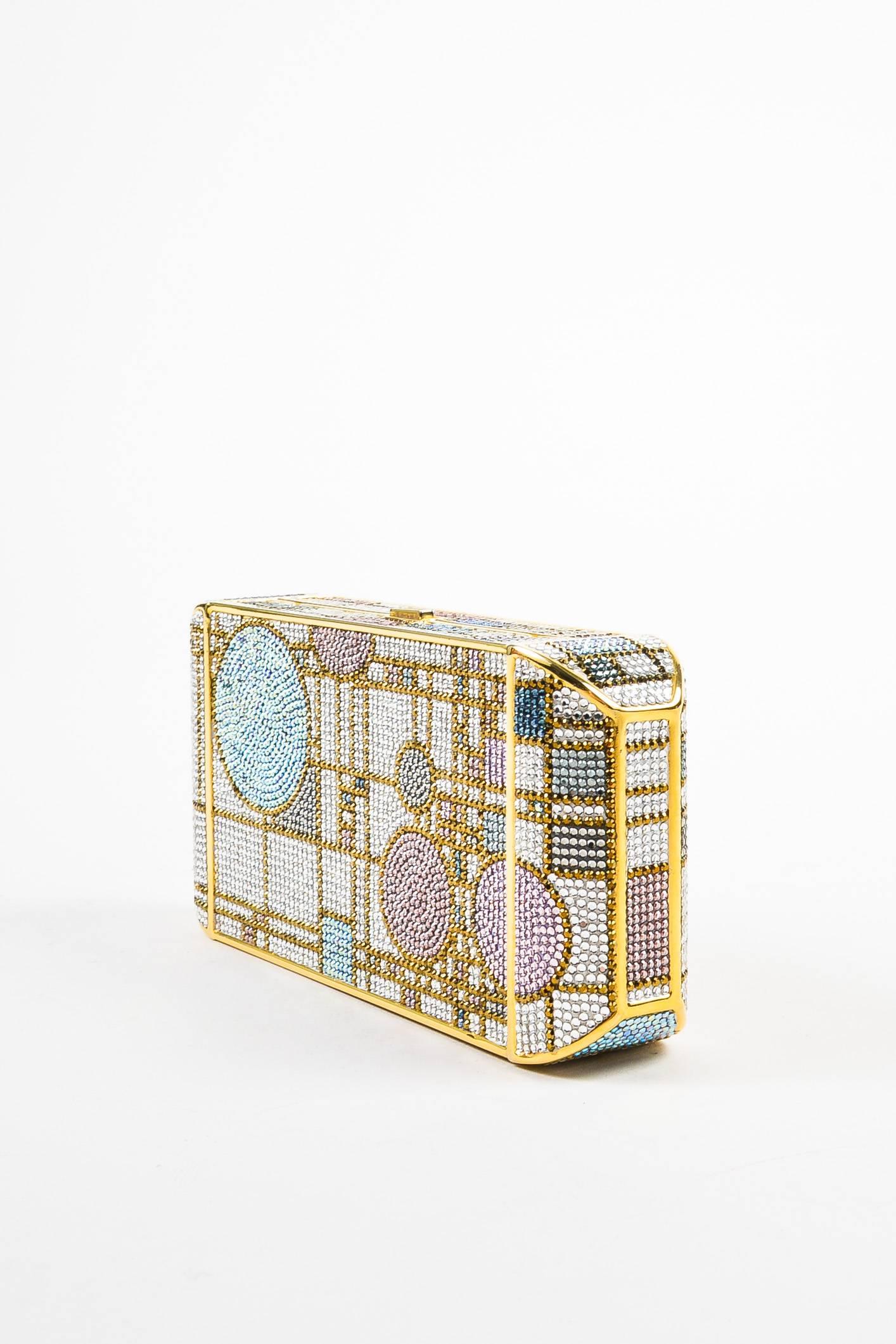 Elevate your evening look with this show-stopping minaudiere clutch bag detailed with a hardshell body, Swarovski crystals in a geometric pattern, snake chain shoulder strap, and a dainty crystal embellished push-lock closure. Comes with a cosmetic