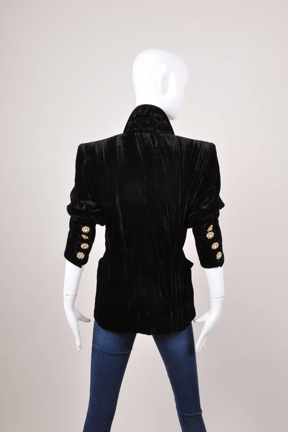 This crushed black velvet blazer features gold-tone and crystal rhinestone trim buttons at front fastening and at sleeve openings. Satin lapels. Lightly padded shoulders. Front hip pockets. Lined.

Additional measurements:
Sleeve length: