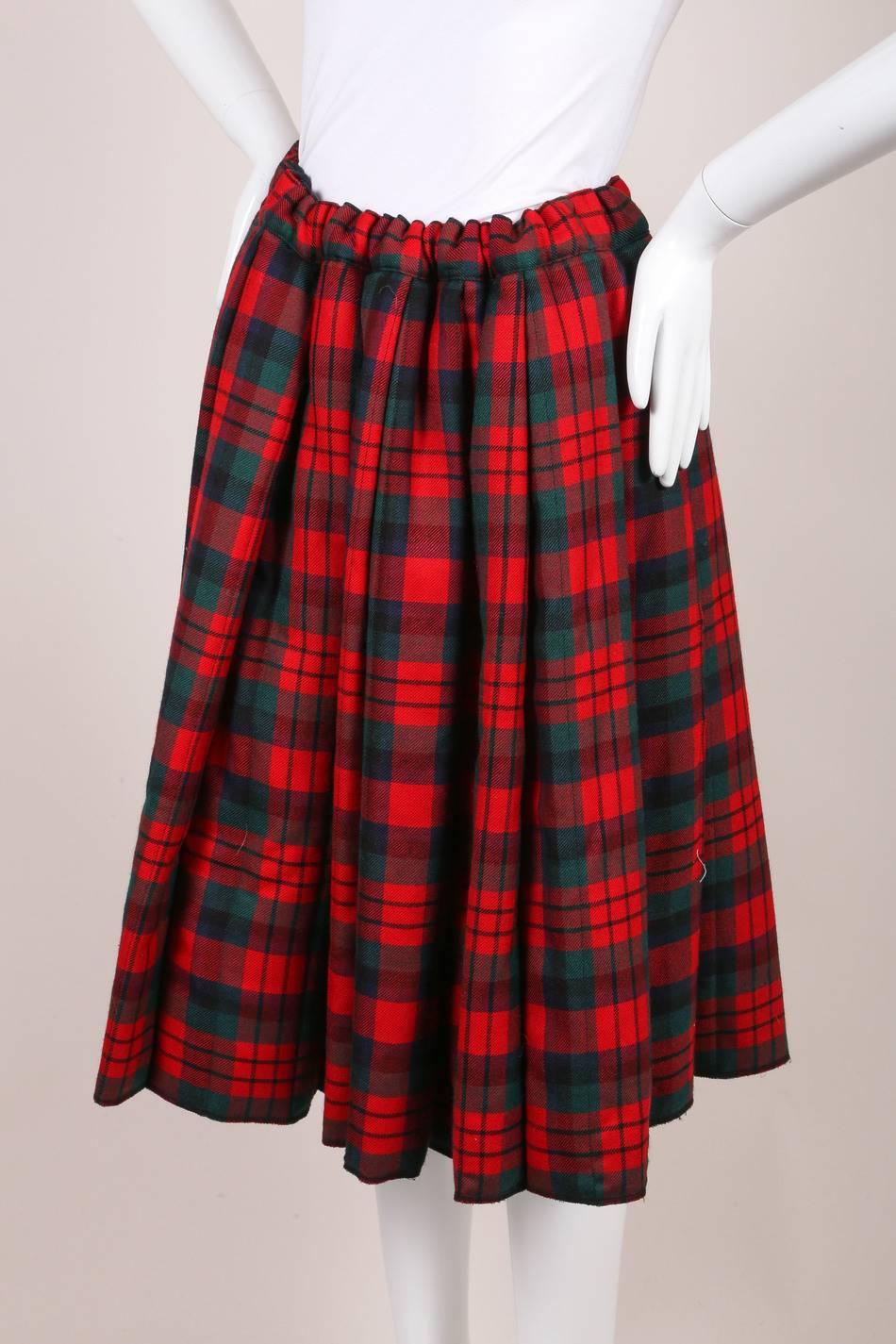 This full, plaid pattern skirt is constructed of wool and pleated throughout. Hits around the knees. Padded. Top drawstring closure. Lined.

