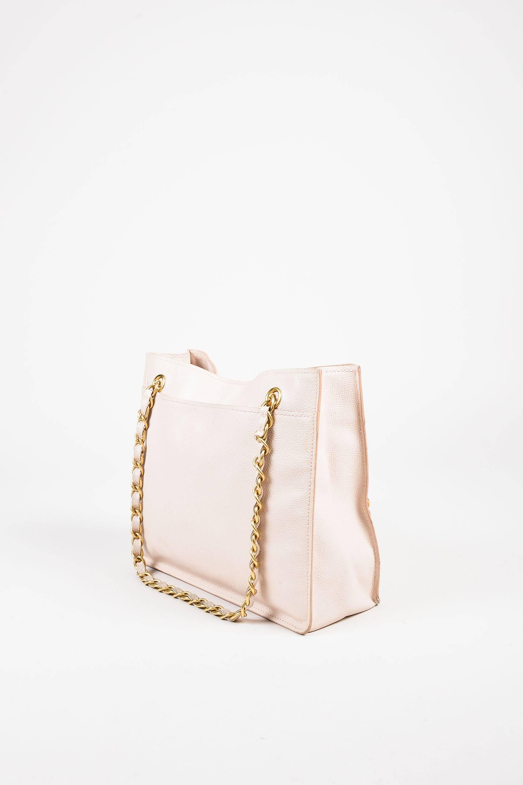 Released circa 2002-2003. Constructed of signature caviar leather, this feminine everyday tote features an interlocking 'CC' detail at the front, chain-leather interwoven straps, a snapped back pocket, and tonal stitching. Serial #: