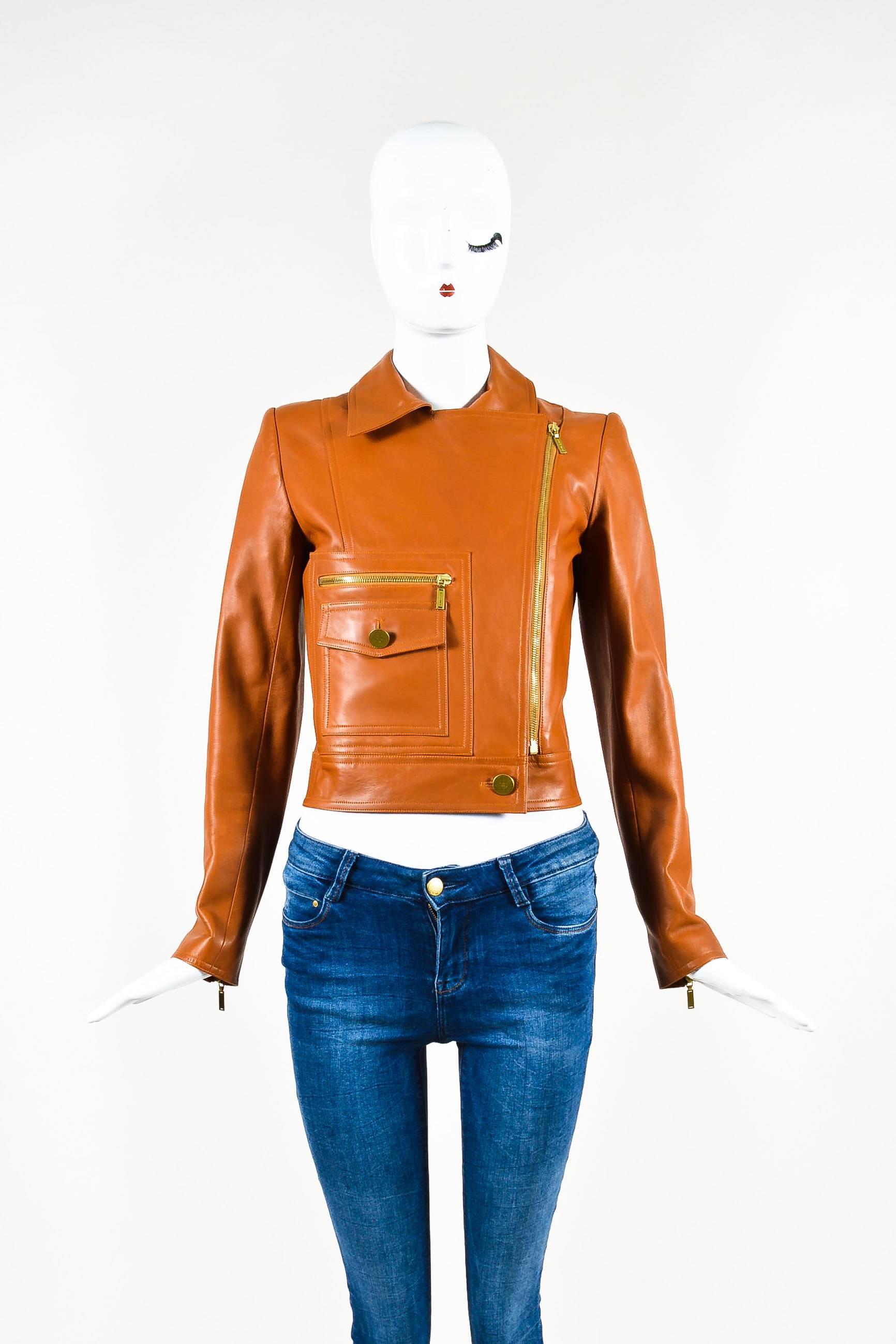 Sleek leather moto jacket for the woman with edgy style. From the spring 2001 collection. Supple lambskin construction. Gold-tone plated hardware. Spread collar. Long sleeves with zip closure. Front zip and flap pockets. Front-bottom button closure.