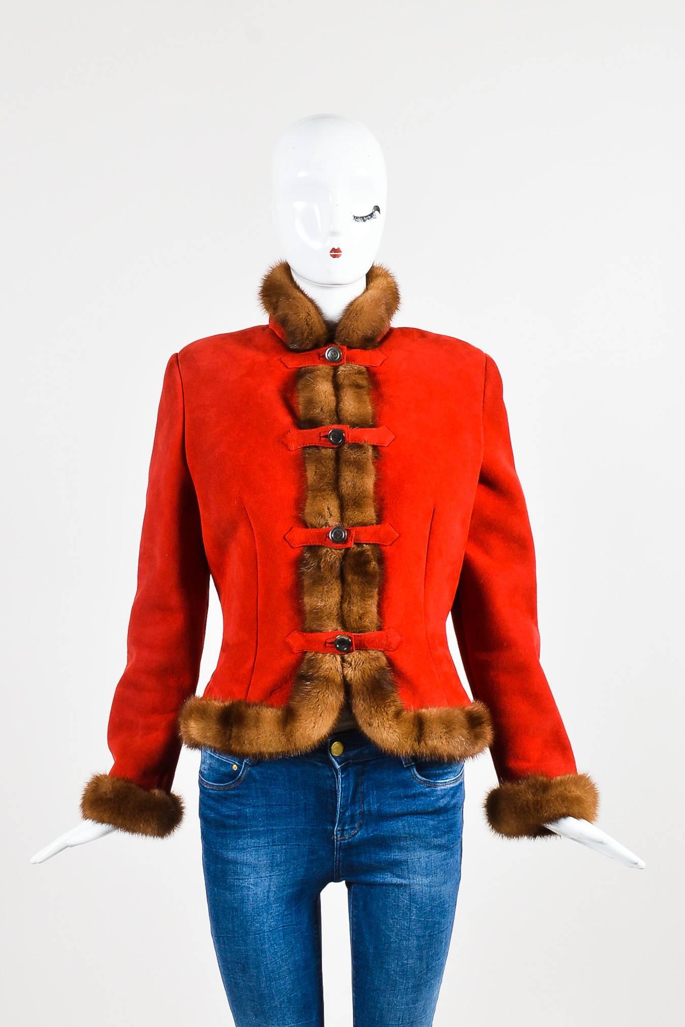 Cold weather jacket. Red suede with brown fur trim. Long sleeves. Darting on bodice. Padded shoulders. Straps with button closures down front. Shearling interior.

Additional measurements: Sleeve Length 23.375", Shoulder -to- Shoulder