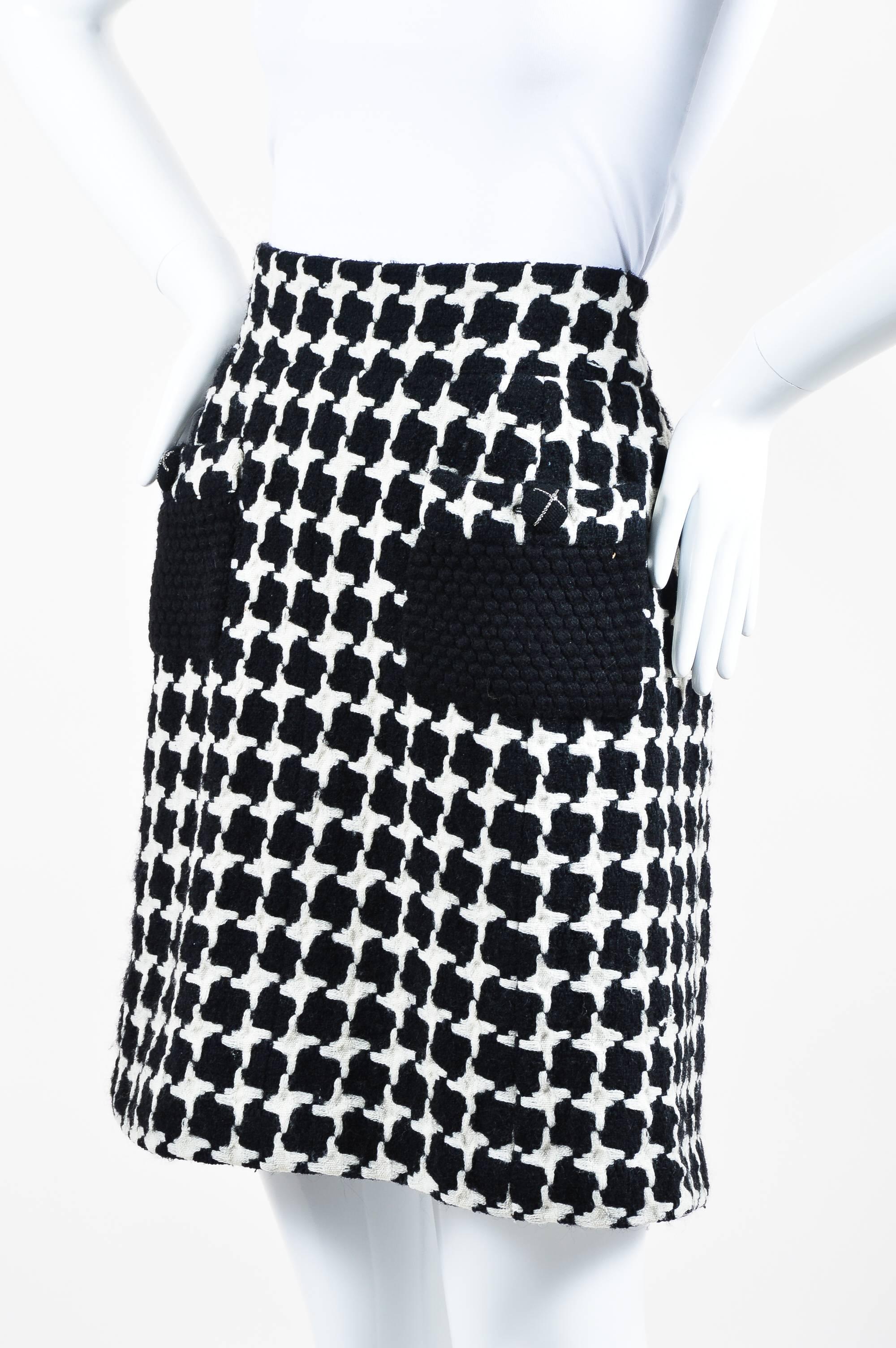 From Fall 2007, this vintage inspired skirt is constructed of a wool blend knit into oversized houndstooth designs. A-line silhouette. Two pockets on front have button closure; each button is detailed with chain trim and a tiny 'CC' logo. Matching