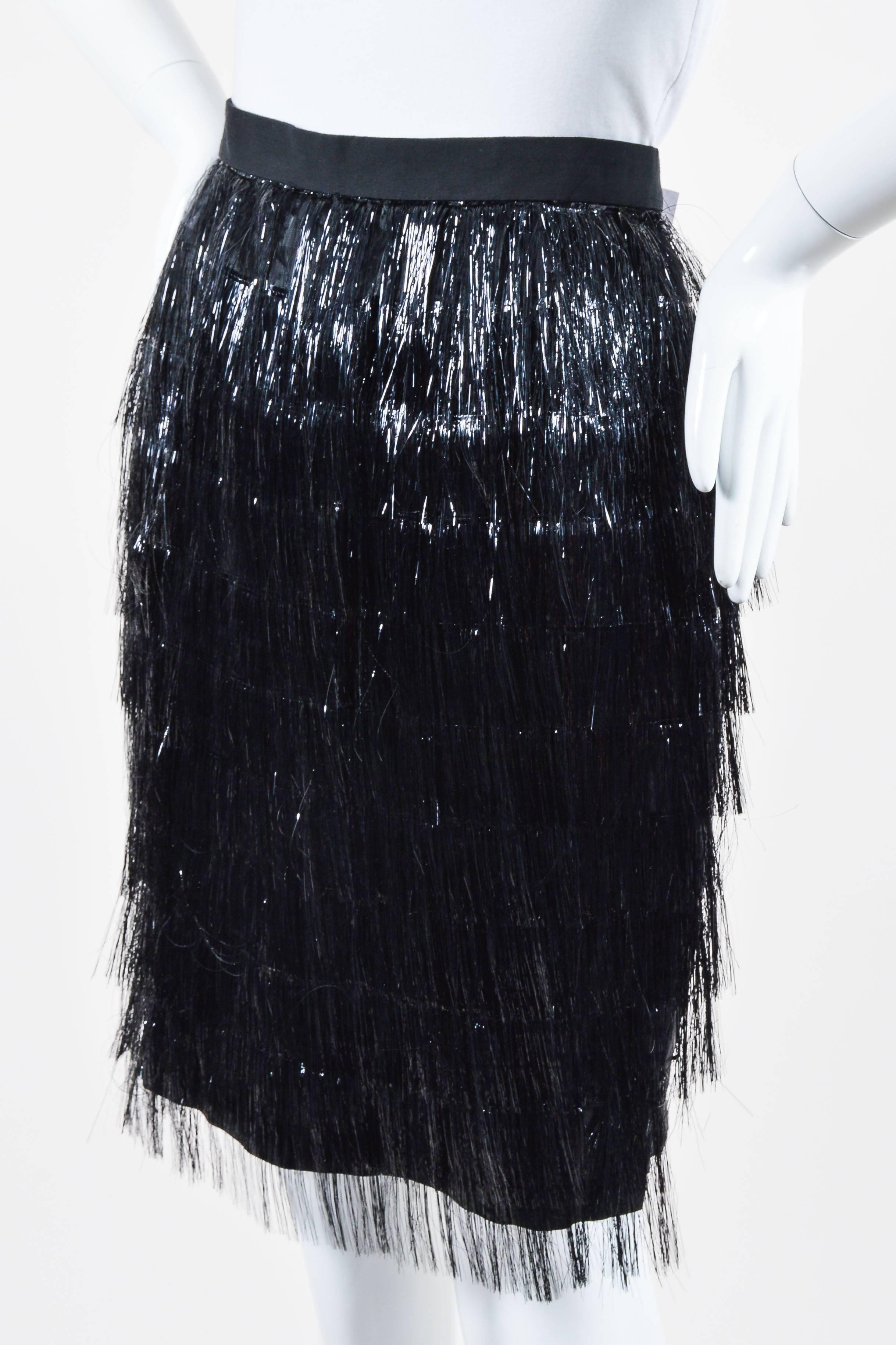 Retails at $1625. Fun and flirty party skirt for a stylish night out on the town. Silk blend textile. Front tiered tinsel fringe embellishment. Hits at knees. Small slit at back. Hidden back zip closure with hook-and-eye closure.