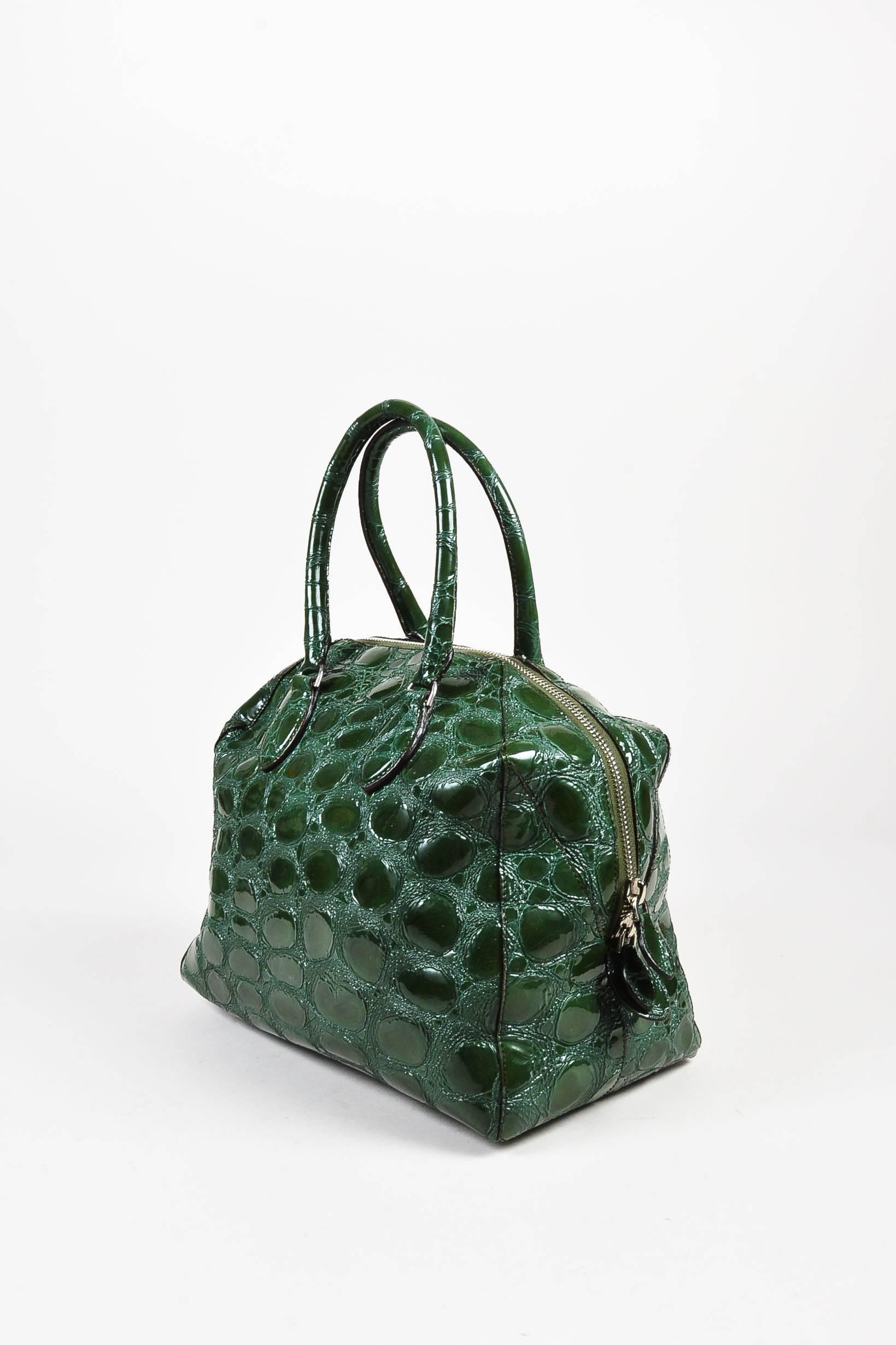 Glossy green embossed patent leather structured tote bag from Alaia. Silver-tone hardware. Two handles. Top zipper for closure. Mauve leather interior lining features a zip pocket and open pocket.

Additional measurements:
Handle Length	: