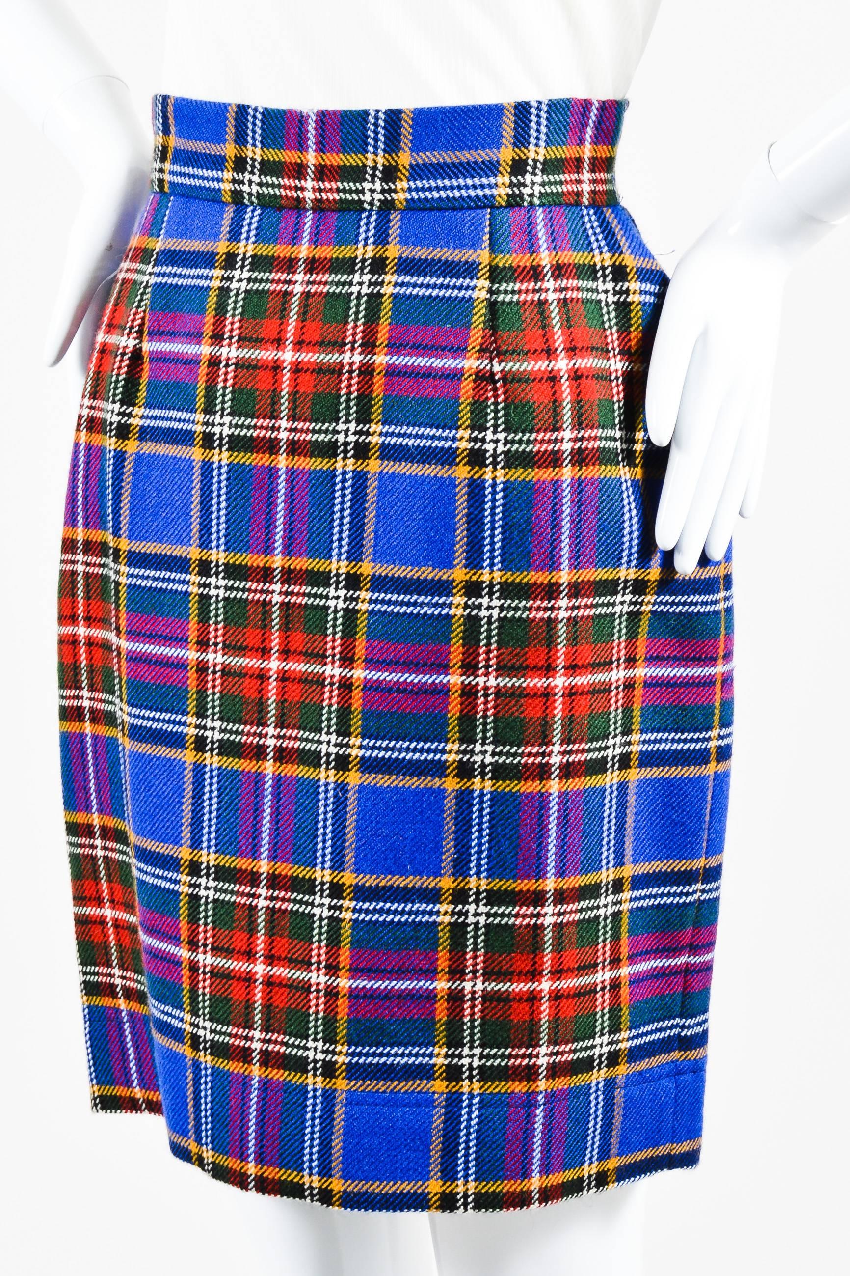 Chic vintage pencil skirt perfect for work, an event or a casual day out. Wool textile. Multicolor plaid pattern throughout. Hits around knees. Back embellished button closure. Hidden back zip closure. Lined.

Size:
6 (USA), 8 (GB), 36 (D), 36