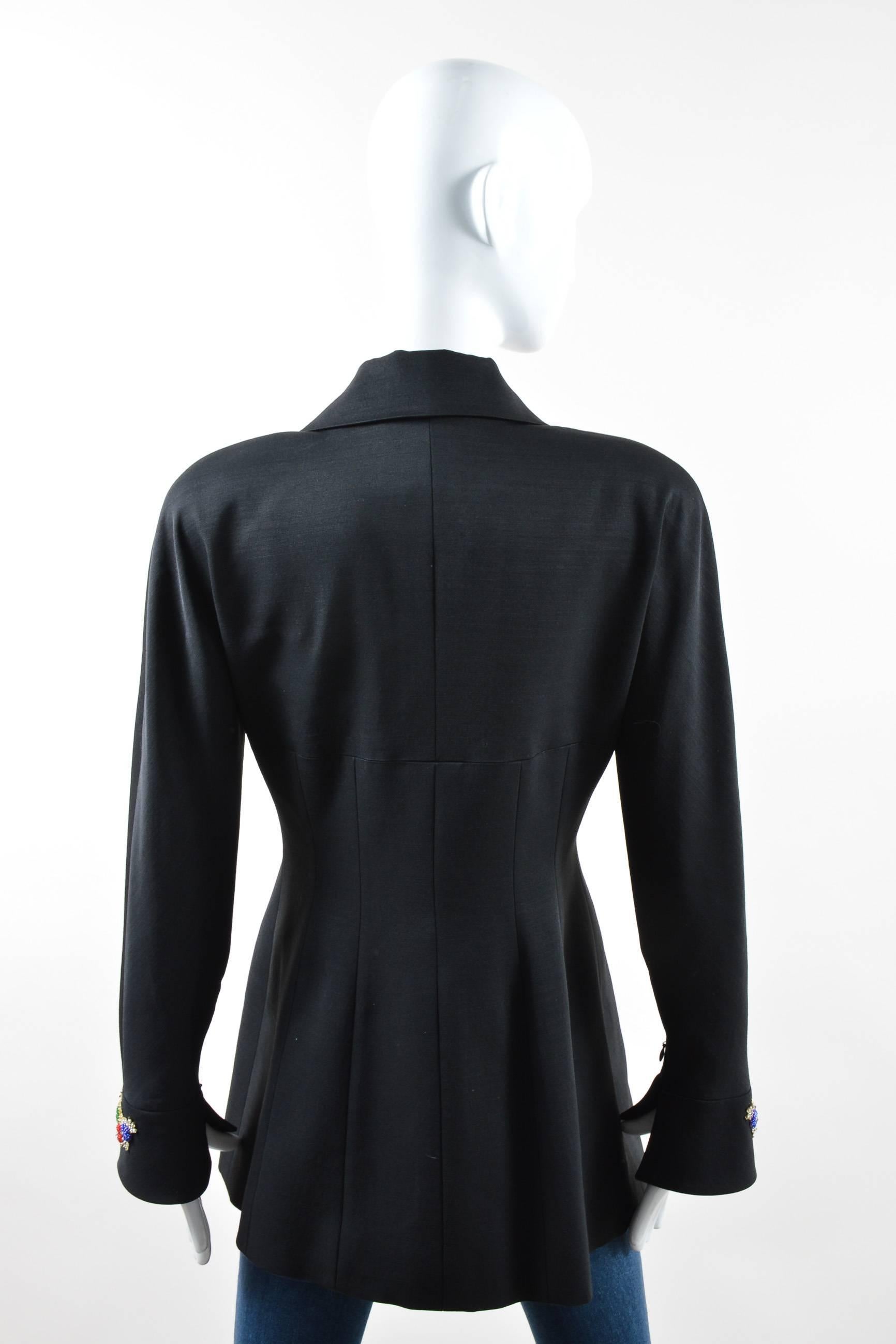 Vintage, tailored blazer. Black wool blend. Long sleeves with bell cuffs & zip closure. Oversized notch lapel. Asymmetrical hemline. Embroidered appliques with beading on sleeve cuffs & front bodice. Padded shoulders. Conceal snap button