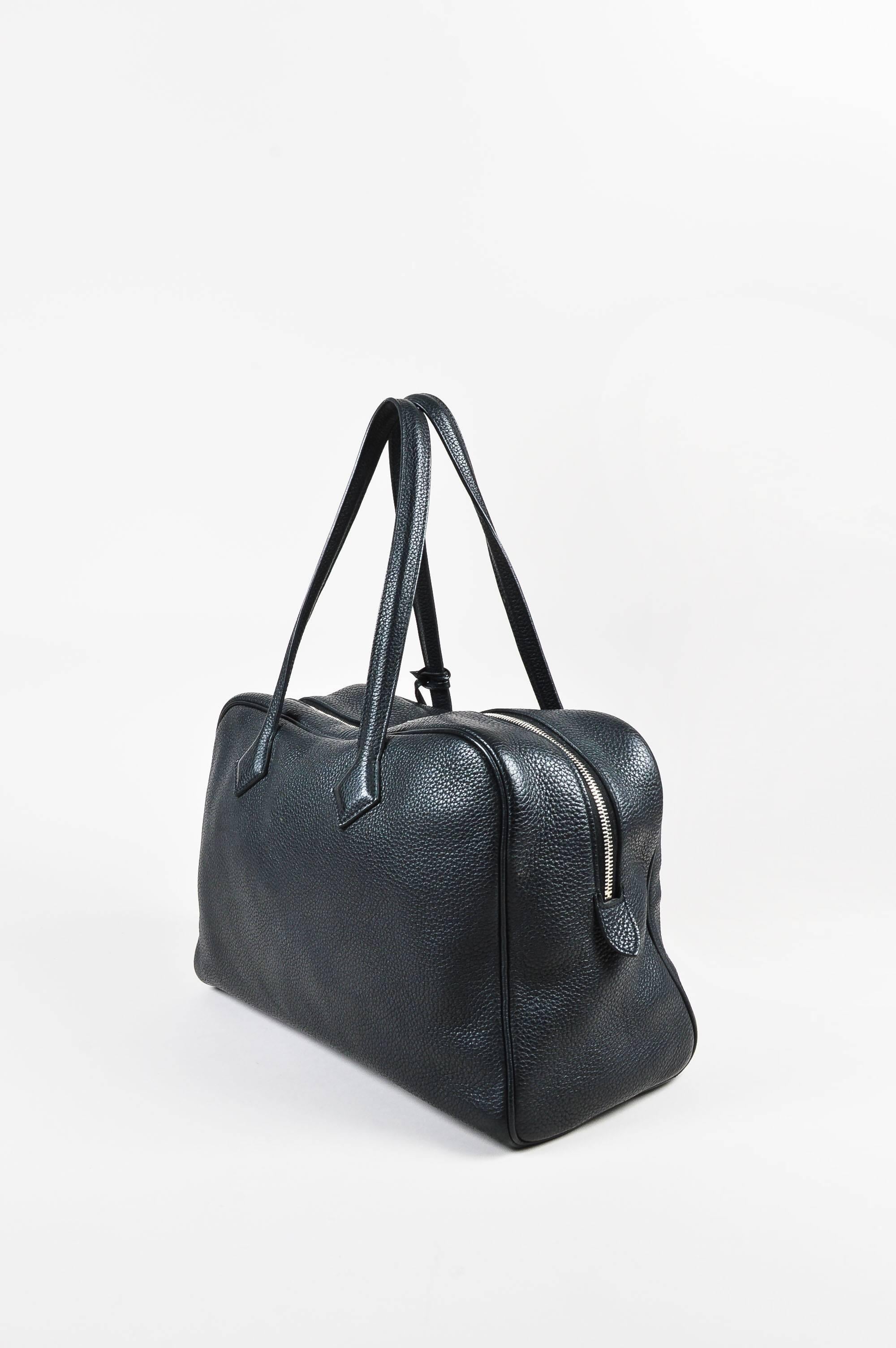 Retails for $5,500. Comes in dust bag. Black Clemence leather bag features two flat straps and double zip closure that secures with padlock and keys. Palladium hardware. Five feet on bottom. Circa 2011.

Additional measurements:
Strap Length: