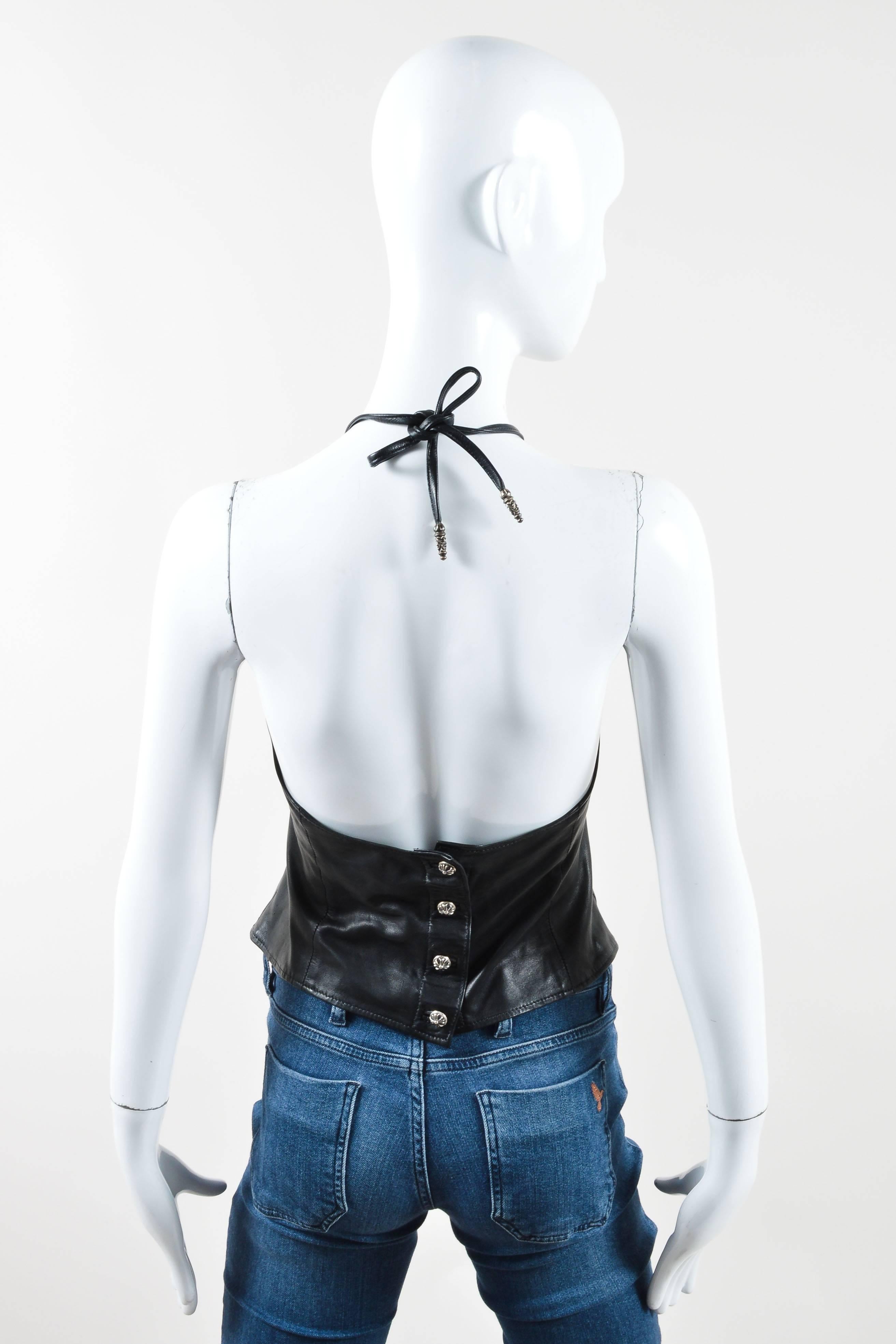 Black leather halter top has sterling silver button closure in back and adjustable ties at neckline. Low, open back. Textile Lined.

Condition details: Pre-owned. This item is in good condition. The metal is intended to have an antiqued appearance