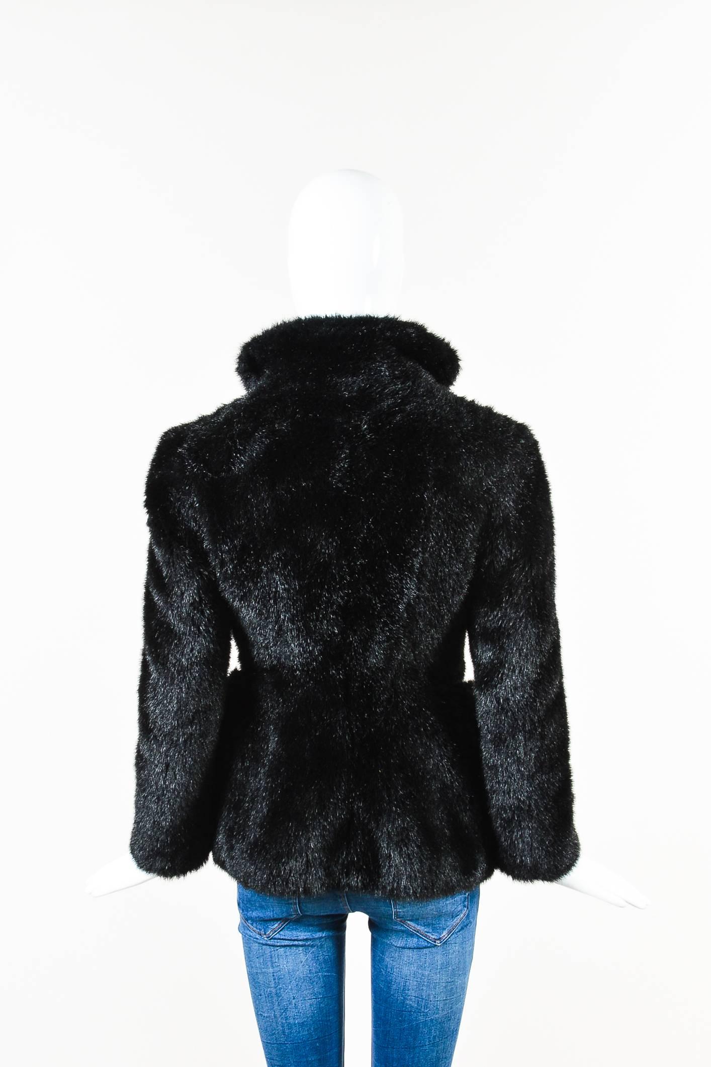 Boxy jacket constructed of soft faux fur features clear PVC panels at sides. Single button closure at front. Bracelet length sleeves. Lined.