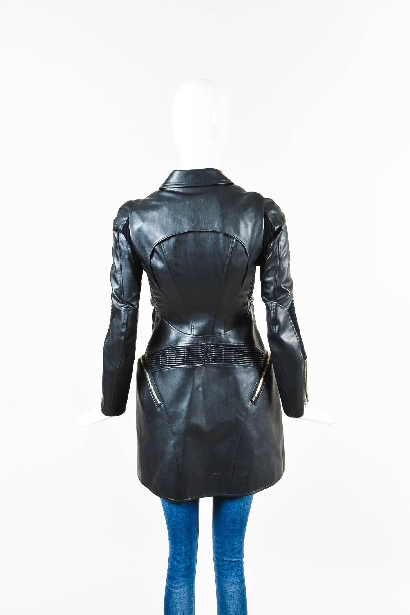 Smooth faux leather construction. Ribbed knit panels. Front gun flaps and back yoke. Exterior zip pockets. Spread collar. Long sleeves. Front double zip closure and center snap button closure. Lined.

Additional measurements: Sleeve Length 24