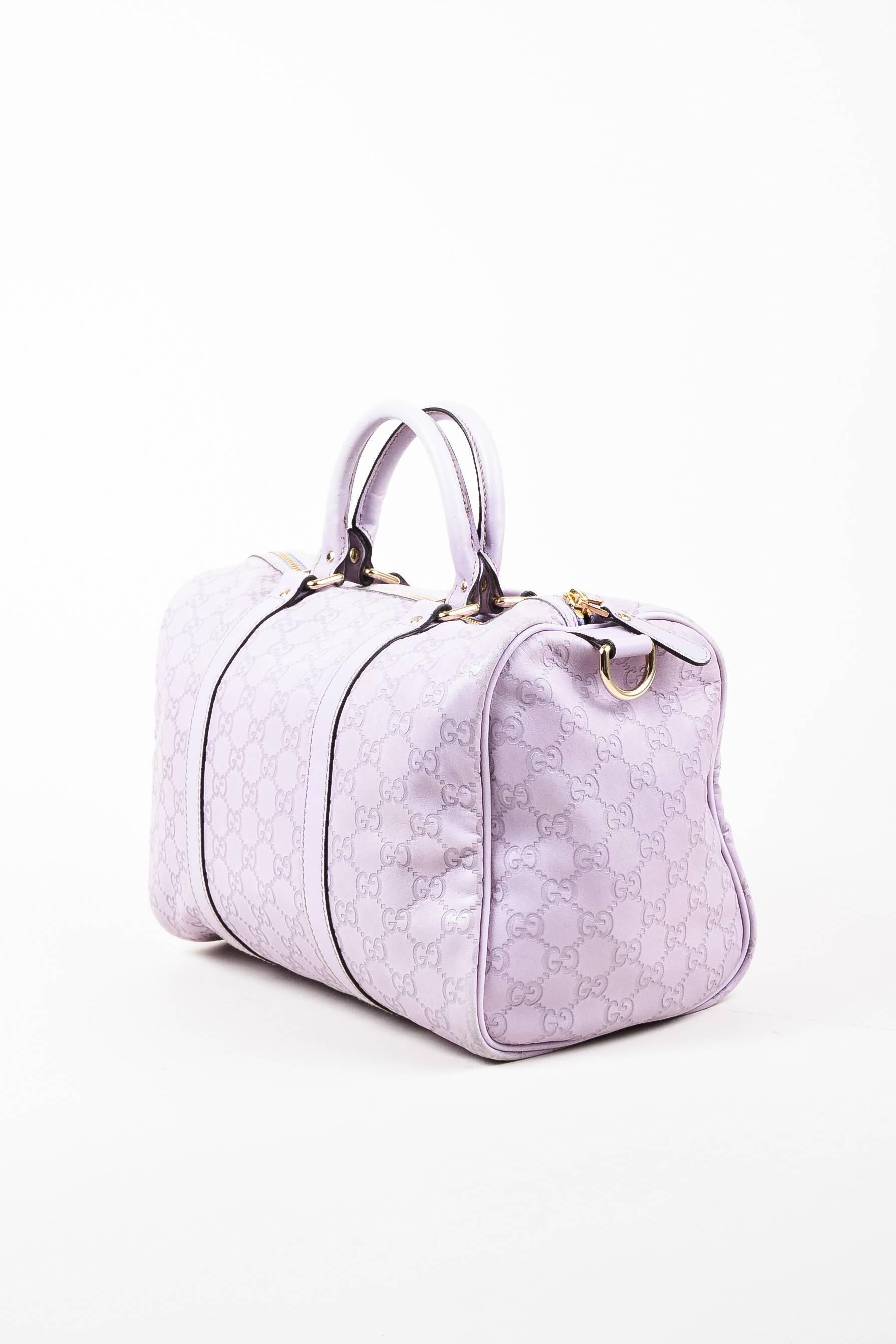 Light purple leather bag is embossed with 'GG' logo. Two rolled top handles and gold-tone zip closure. Serial number reads, 