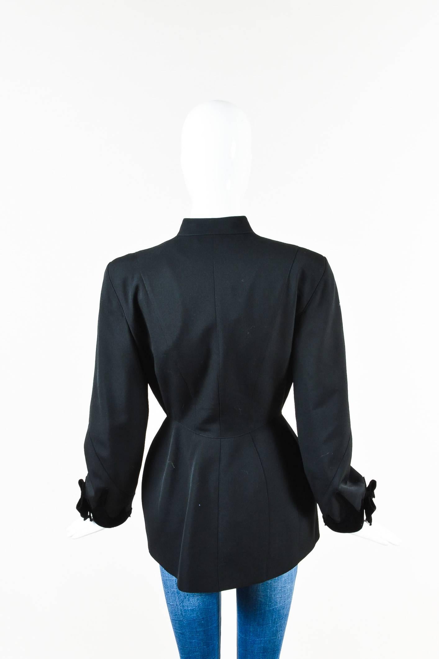 Wool construction. Velvet trimmings with bow accents. Paneled seams. High neck. Long sleeves. Padded shoulders. Front hook-and-eye and snap button closures. Lined.

Condition details: Pre-owned. This item is in good condition. Light wear around