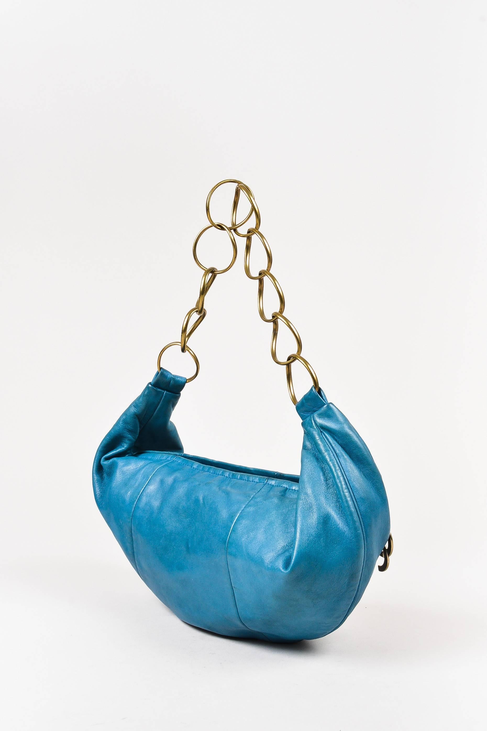 Teal leather hobo bag from Chanel circa 2002. Top zipper for closure with a bronze tone 'CC' logo plate on the pull tab. Bronze tone circular rings along the strap. Interior lining features a zip pocket. Comes with dust bag,

Interior features: