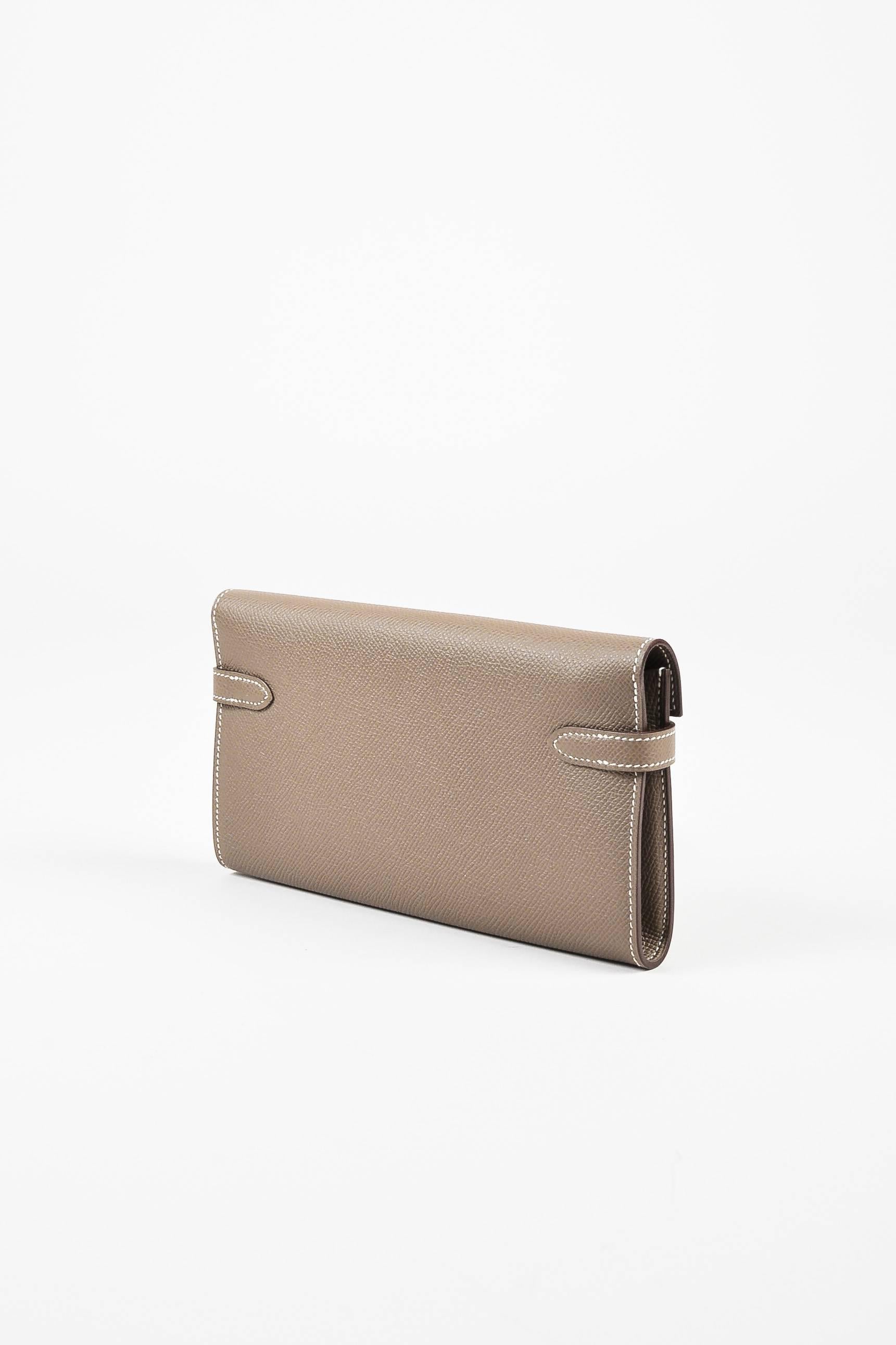 The timeless "Kelly" wallet is as chic as its namesake. Supple epsom leather construction. Silver-tone hardware. Front straight flap with plaque; sangle straps pull through touret. Two open compartments. Twelve card slots. Two billfold