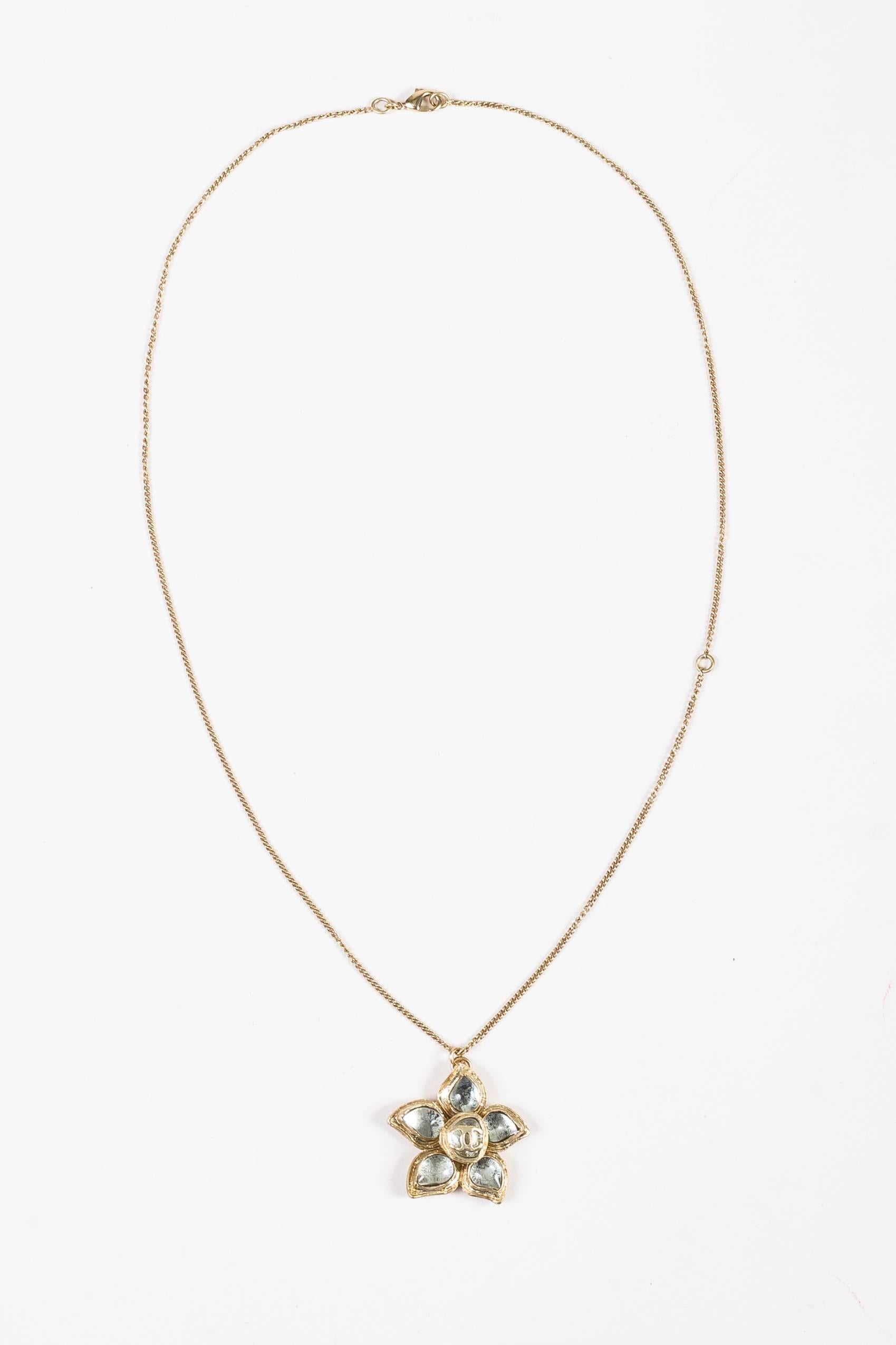 Beautifully constructed necklace for simple elegance. From the fall 2012 collection. Light gold-tone hardware. Curb link chain. Signature camellia flower shaped pendant with clear gripoix petals. Center 'CC' logo accent. Lobster claw clasp