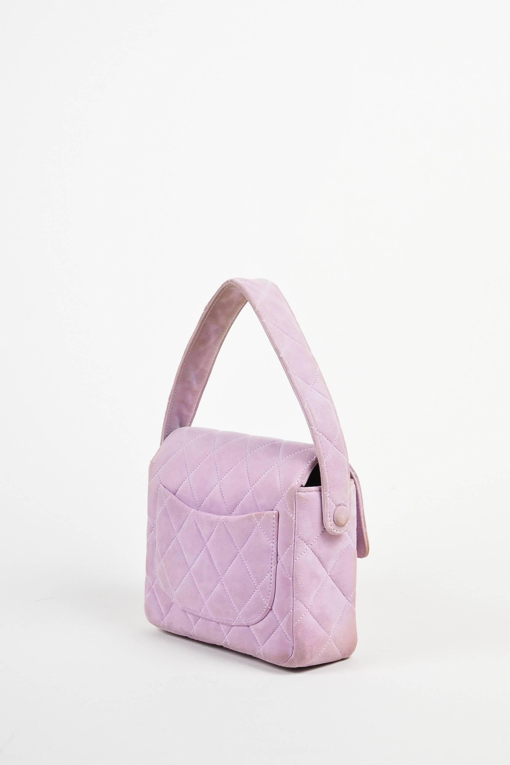 Comes with dust bag. Chic and eye-catching lavender purse from Chanel. Suede exterior with silver-tone hardware and a turn lock closure. Quilted design that is iconic of the brand. Small shape and size is great for everyday use. Will hold all of
