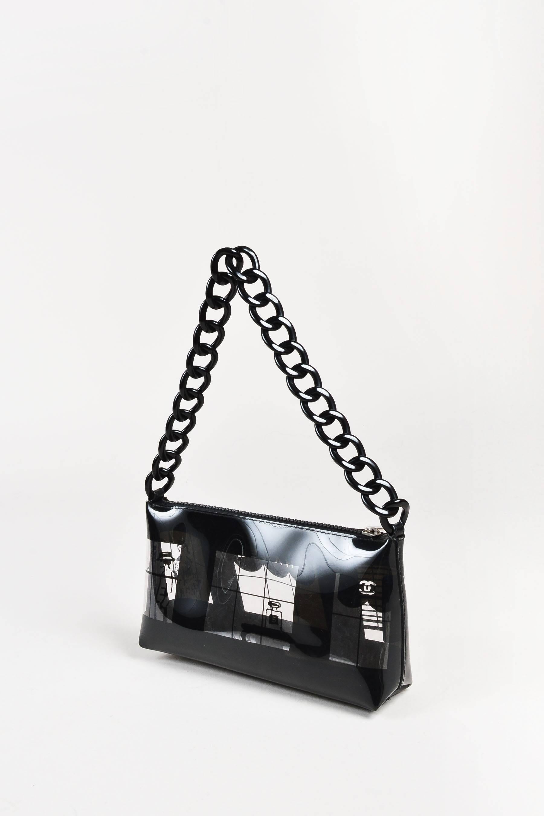 Chanel clear and black vinyl shoulder bag printed with a boutique window pane design along each wall. Featuring a playful twist on the brand's signature chain design, this bag features an acrylic chain link strap. Zip top closure. Silver-tone metal