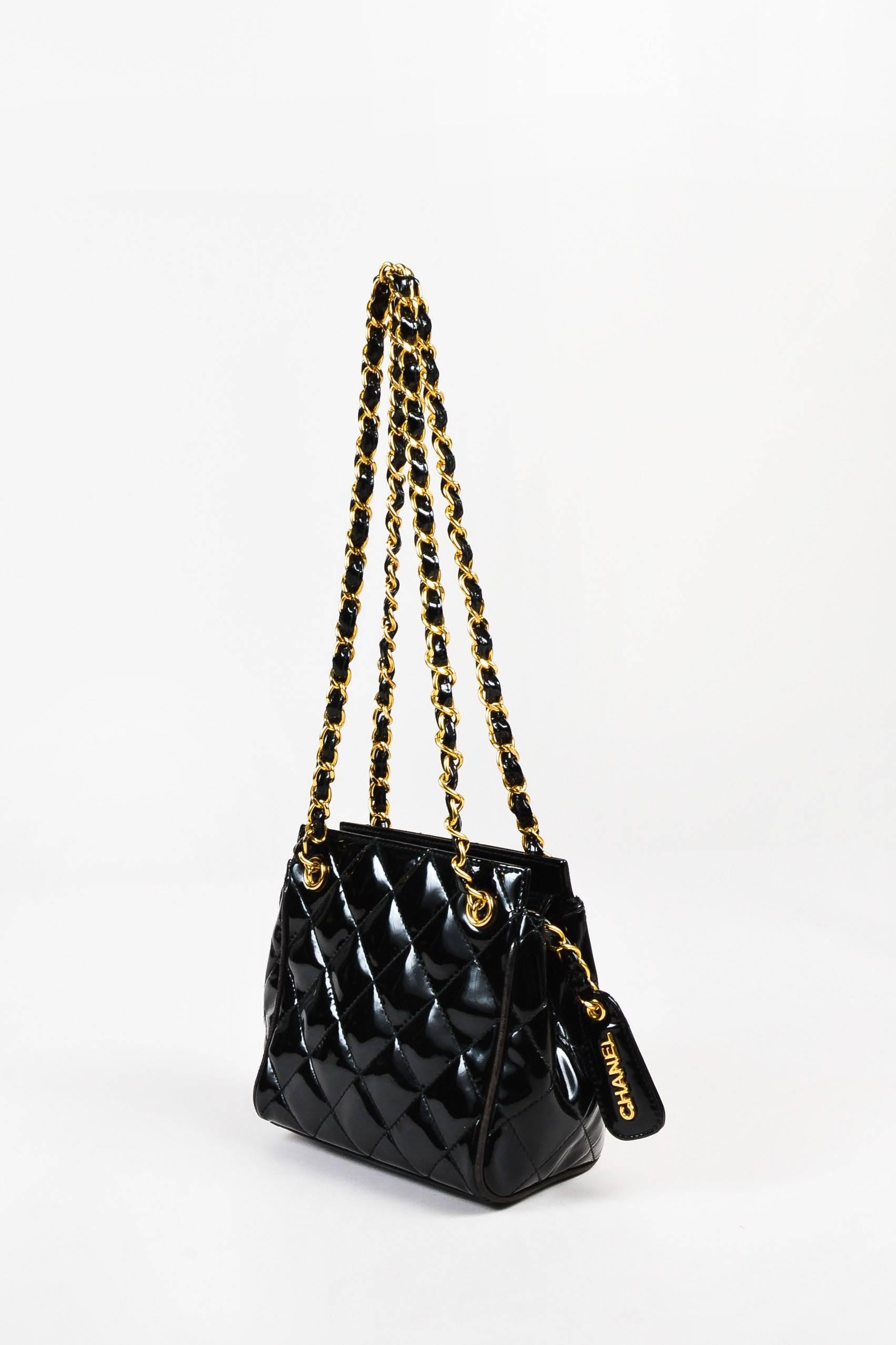 Vintage patent shoulder bag by Chanel designed with the brand's signature quilted stitch pattern. This miniature classic features two gold-tone metal chain straps woven with patent leather trim and a 