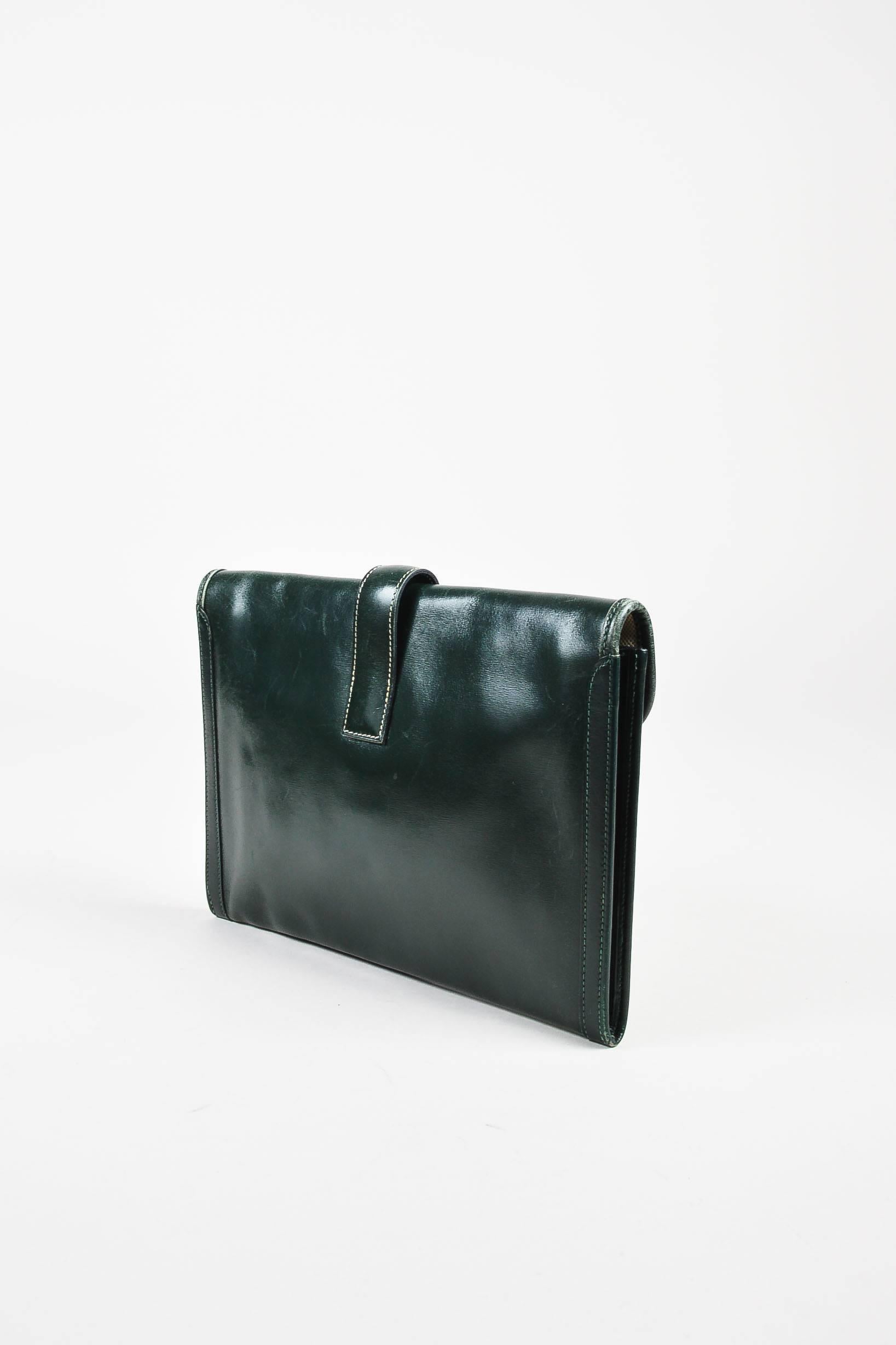 Color: Green
Made In: France
Fabric Content: Leather

Item Specifics & Details: Vintage hunter Green envelope "Jige PM" clutch by Hermes. 'H' detail on front of clutch with tuck-strap closure. Circa 1984.
Measurements*:
Height: