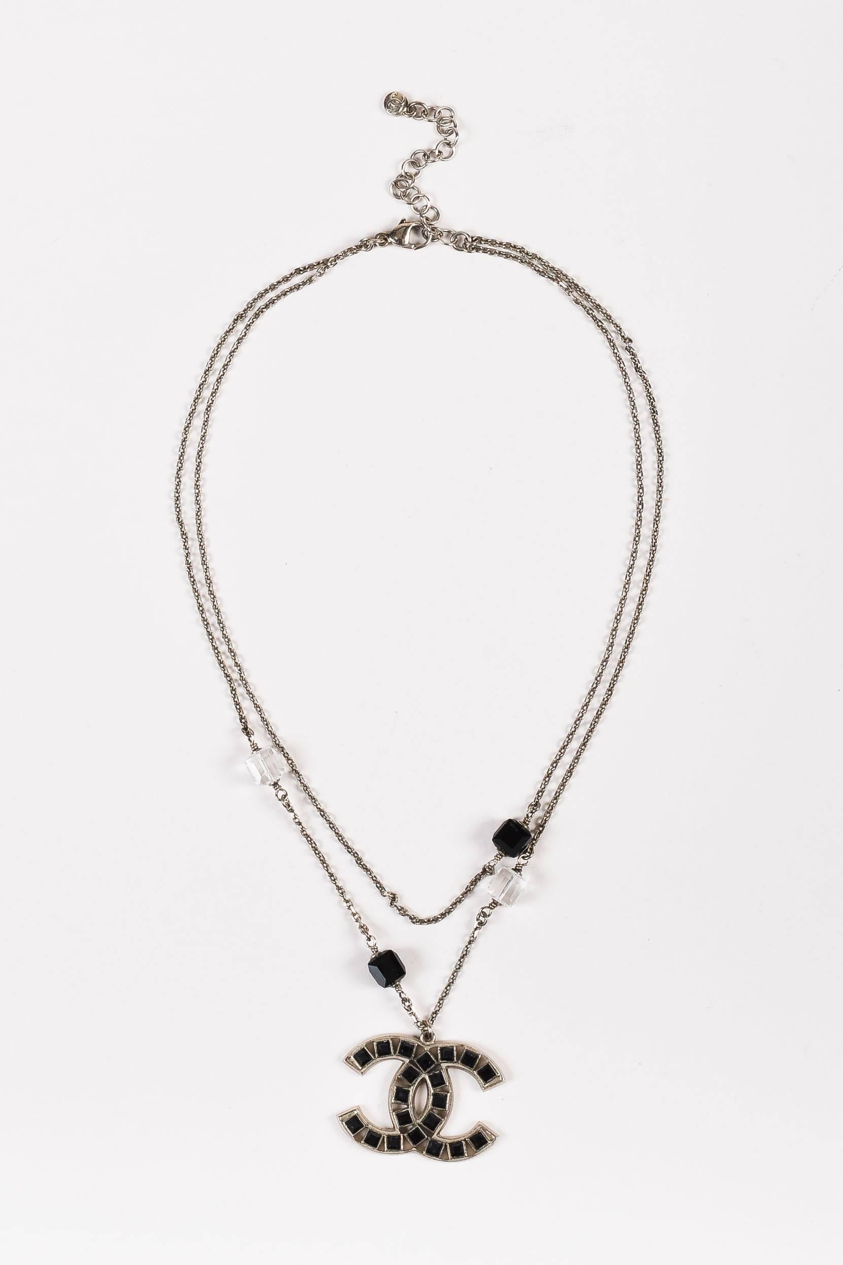 From the 2008 Spring Collection. This versatile Chanel necklace transitions effortlessly from day to night. Silver-tone metal. Two layered cable chains. Sparkling black & colorless Swarovski crystals. Iconic 'CC' logo pendant. Extender for