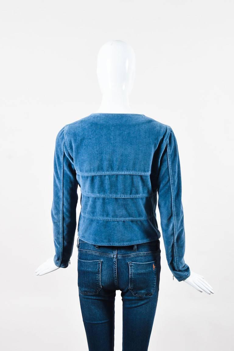 Dusty blue velvet jacket by Chanel.  This jacket features a hidden button front closure, two flat pockets near waist with button closure, and long sleeves.  Zip detail at sleeve cuffs.  Unlined.  Comes with original tag, extra fabric, and extra