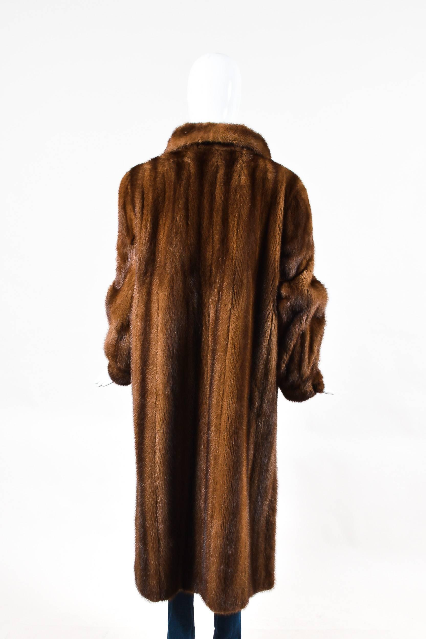 Vintage brown fur long coat from Oscar de la Renta. Thick collar. One button and three hook and eyes down the front for closure. Shoulder pads for a structured look. Two front open pockets. Cuffed sleeves with button closures. Long slits on the side