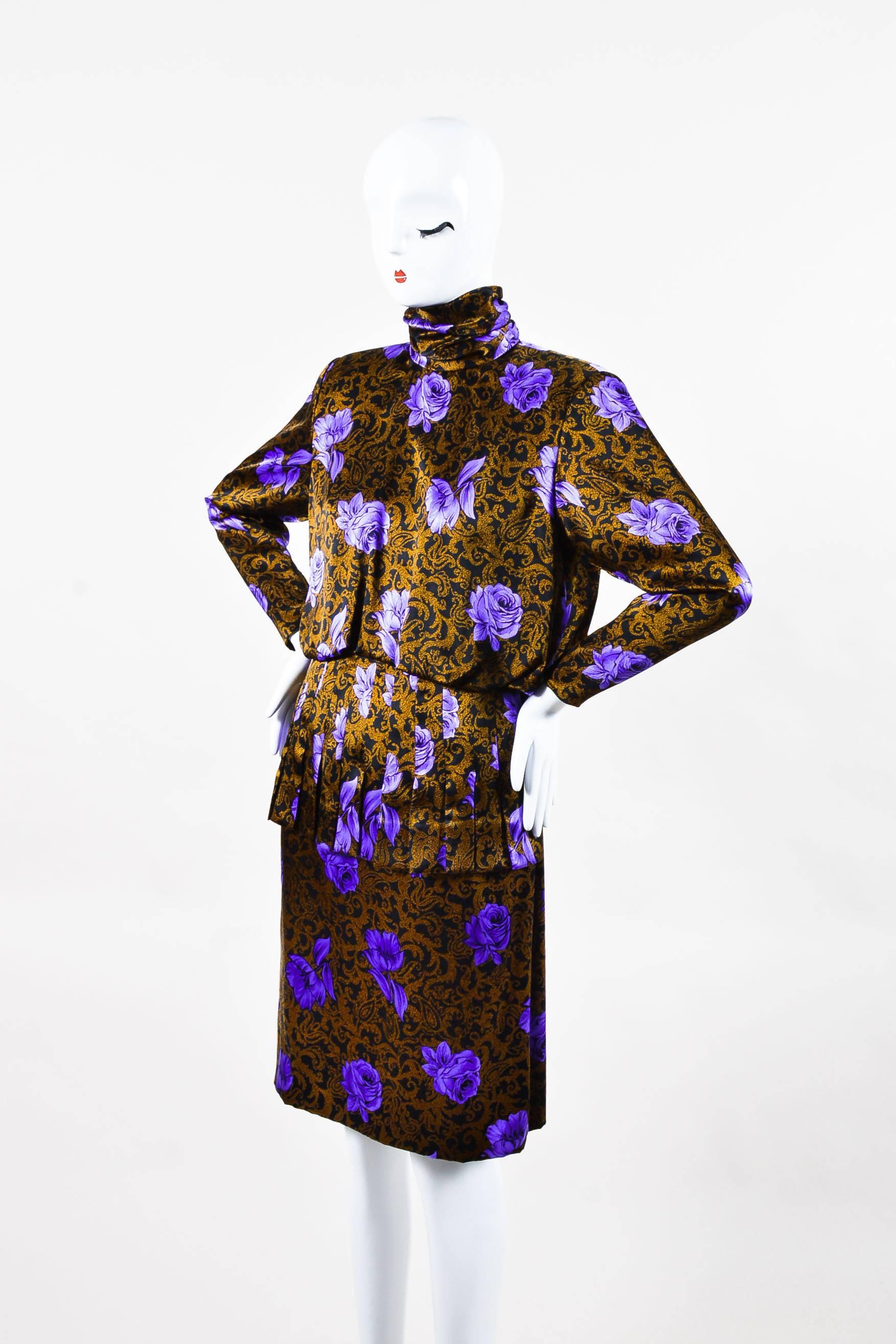 Vintage black, purple, and gold printed silk, long-sleeve dress by Galanos. Features a draped cowl high neckline, non-removable shoulder pads, and a back zipper and hook closure. Back gemstone buttons. Zipper closure on cuff of sleeves. Black