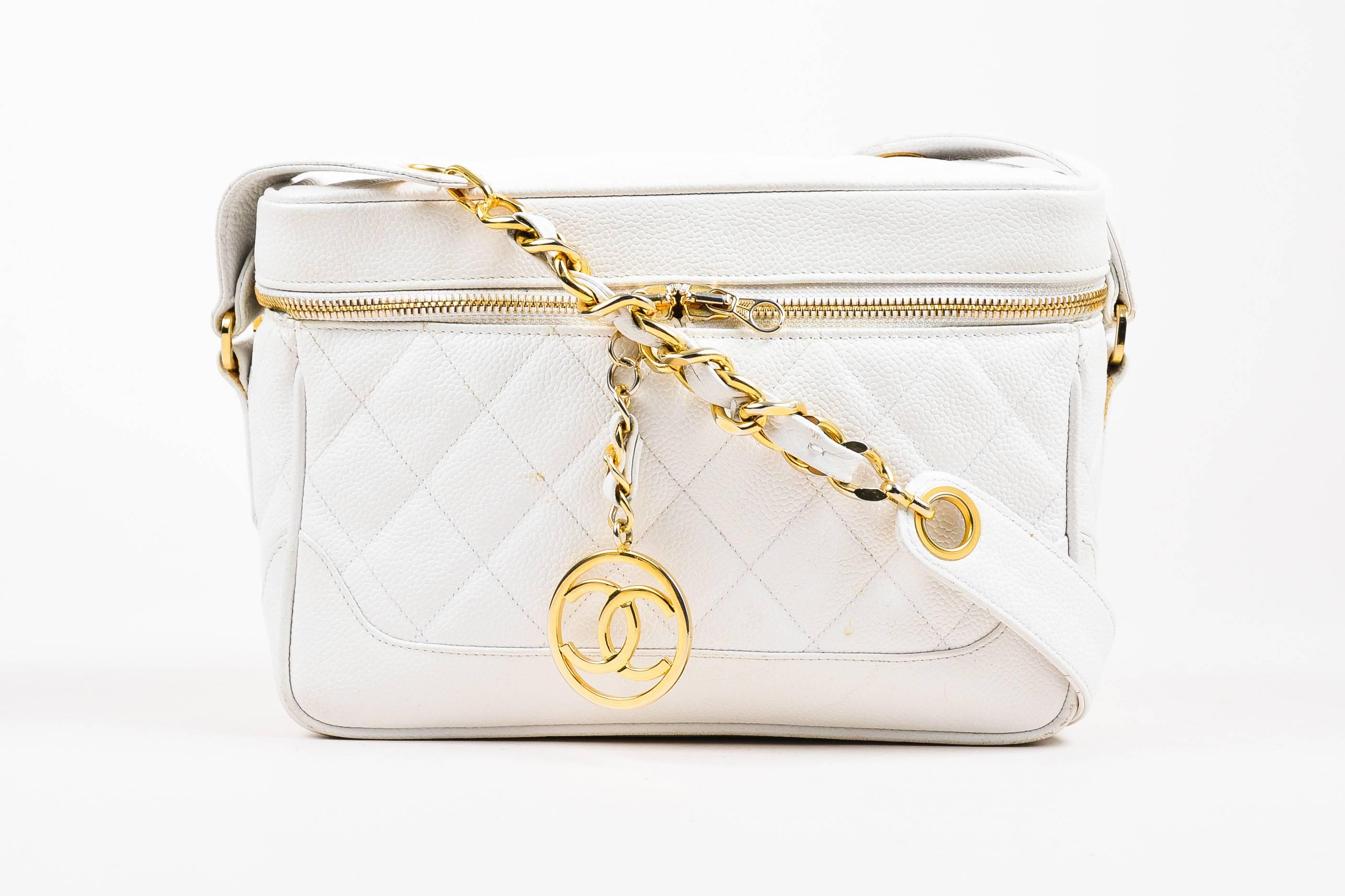 Add elegance and style to your look with this vintage white camera bag. Circa 1989-1991. Constructed of quilted caviar leather. Detailed with gold-tone hardware. Double zip fastening with dangling 'CC' zipper pull. Flat shoulder strap. Comes with