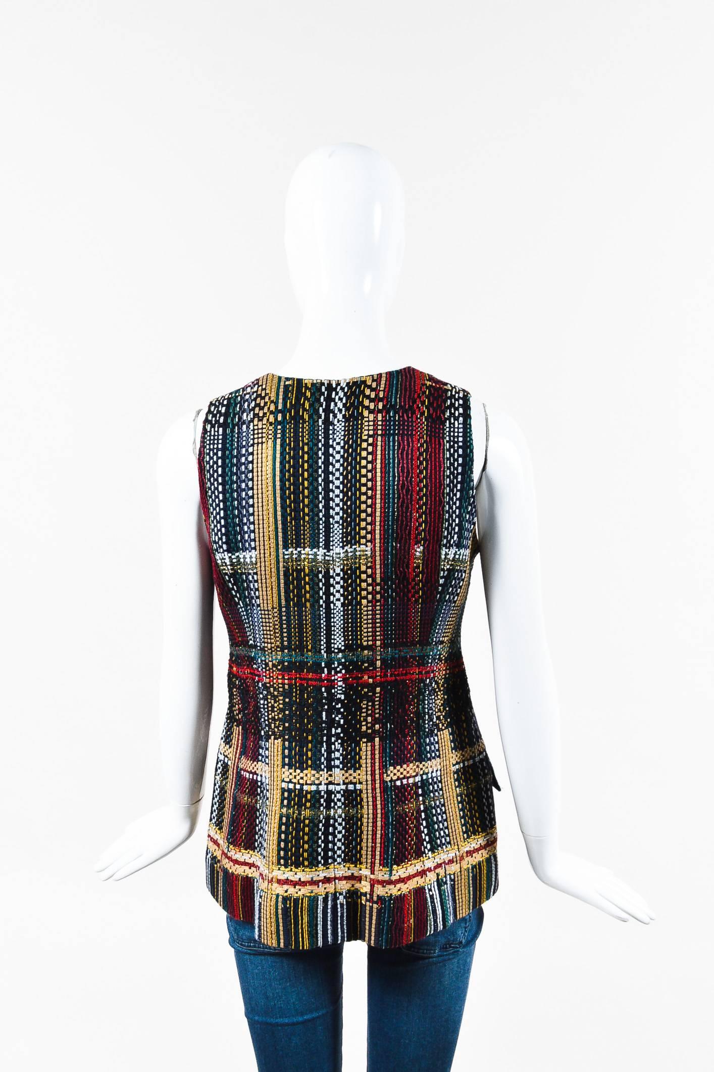 Multicolor tweed, sleeveless v-neck vest by Chanel. Features maroon and gold-tone floral buttons along front. Faux front hand pockets. Beige silk lining. As seen in the Dubai Resort Collection on the 2015 Runway.

Additional measurements: Waist