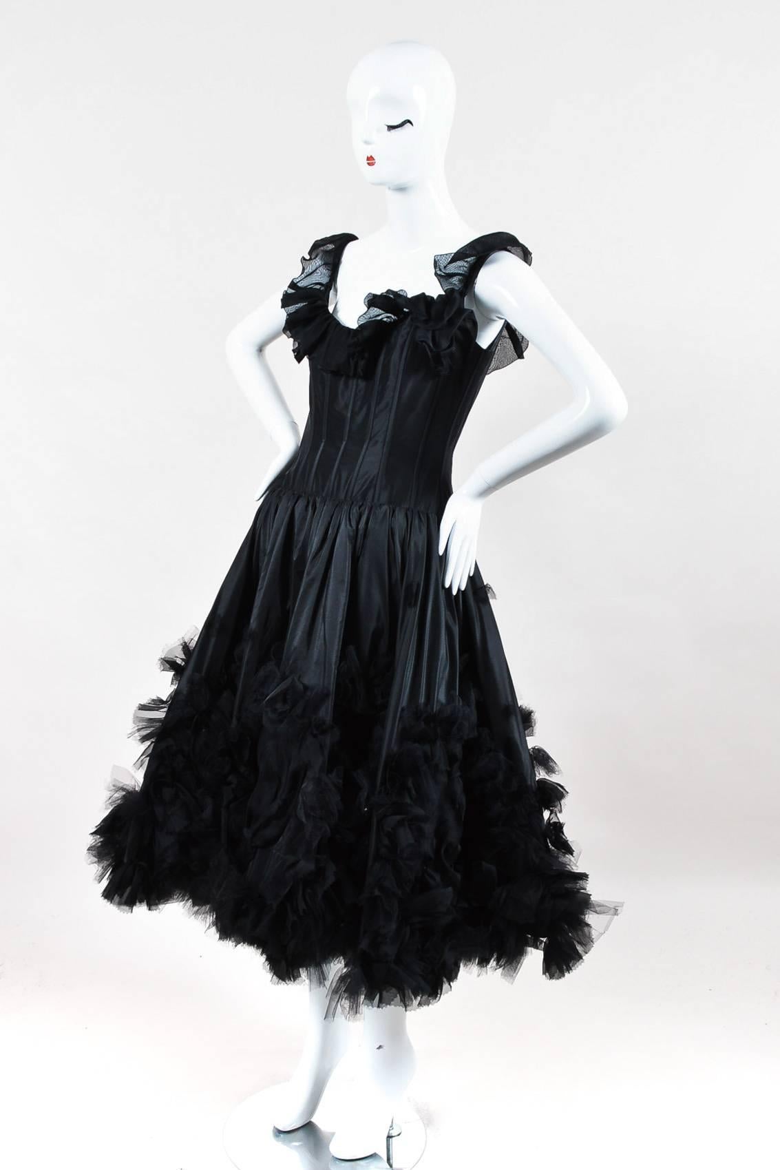 From the 2007 Oscar de la Renta Resort Collection. Romantic black silk taffeta sleeveless dress with ruffles along neckline. Boned fitted corset bodice and full, flared skirt. Large rosettes and ruffles decorate skirt. Hidden back zip closure.