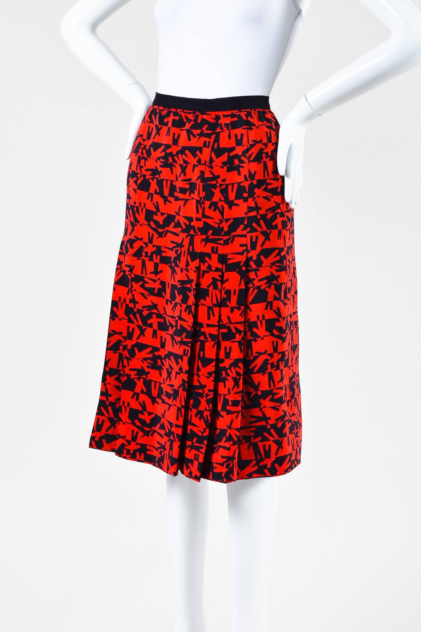 Red and black abstract patterned midi skirt by Chanel Boutique.  This skirt features pleating throughout, black waist band with back button closure, and gold tone back button.  Fully lined.

Condition details: Pre-owned.  This skirt is in great