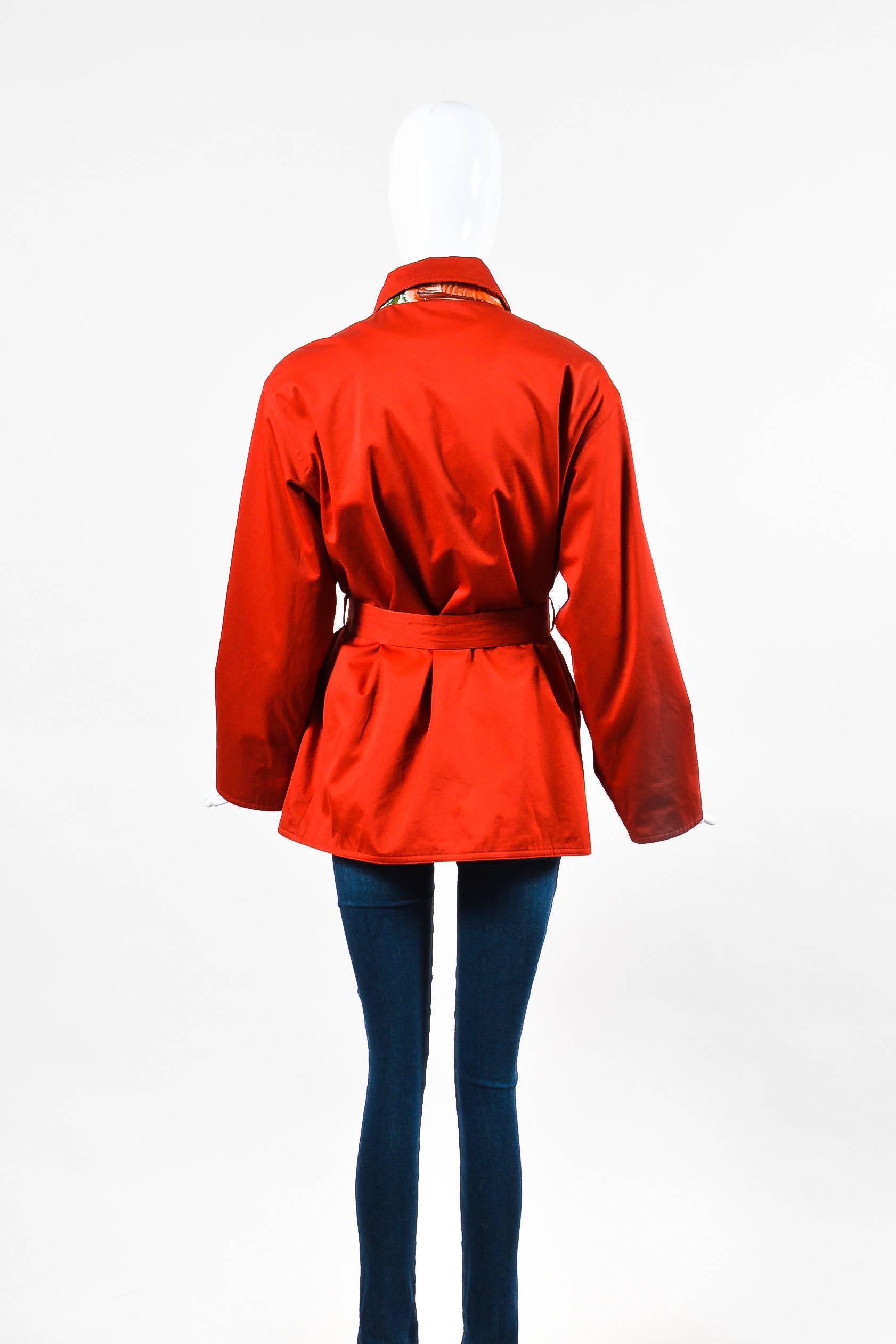 Vintage and rare red-orange reversible jacket by Hermes.  This jacket features Texas print by Kermit Oliver on other side.  Each side has two front flat pockets near the waist.  Long Sleeves.  Collared neckline.  Optional waist belt.

Additional