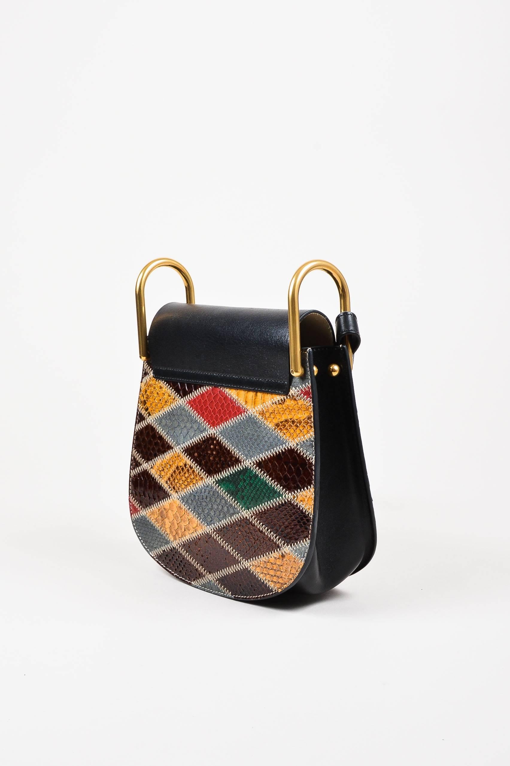 Retails at $3250. Comes in dust bag. "Hudson" shoulder bag is made from black leather featuring patchwork python panels. Shoulder strap attaches with oversized gold-tone rings. Snap closure and pocket under front flap.

Interior
