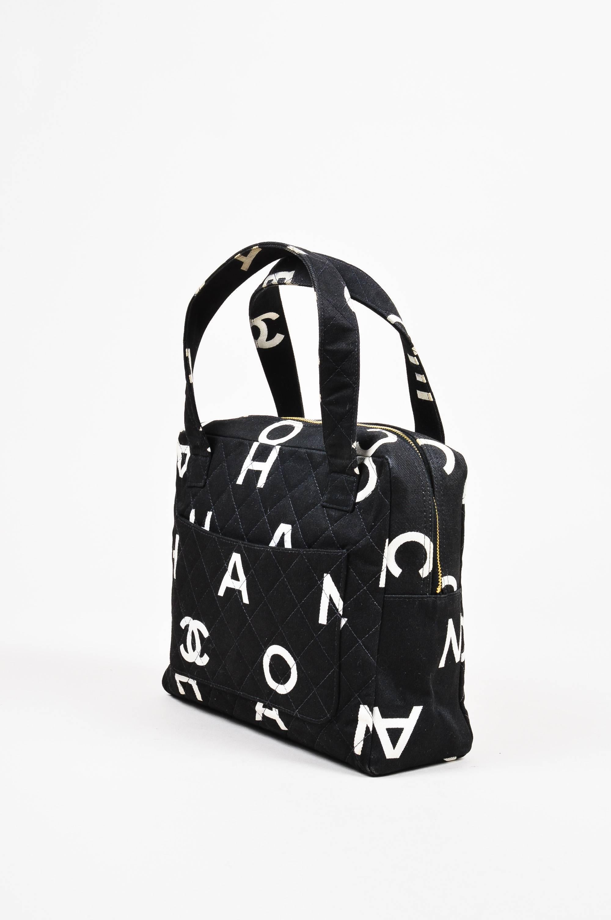 This vintage bag would pair well with a red blazer and black skinny leg pants. Black and white quilted canvas bag from Chanel circa 1996-1997. Printed 'CC' monograms and printed letters throughout spell "Chanel." An open pocket on the