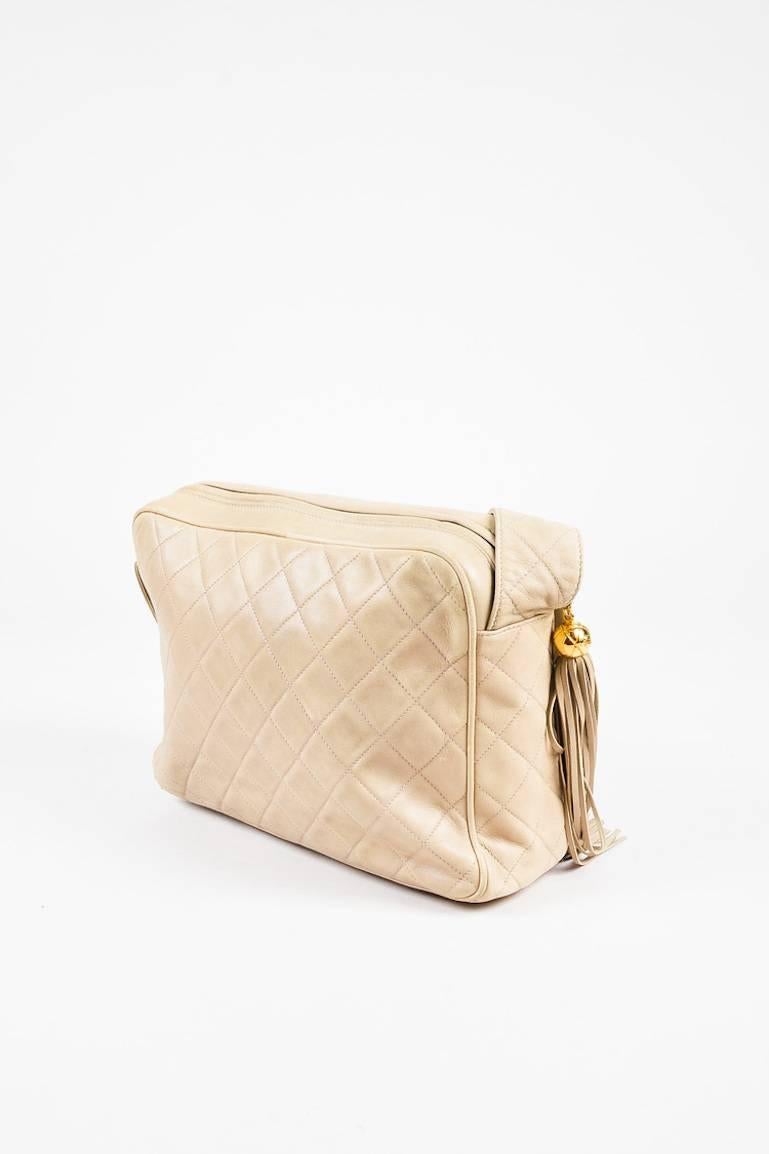 Beige quilted lambskin leather shoulder bag from  Chanel circa 1991-1994. Front flap pocket with a gold-tone 'CC' turn lock closure. Top zipper for closure. Fringe tassel on the zipper pull tab. Single strap for wear. Brown leather interior features