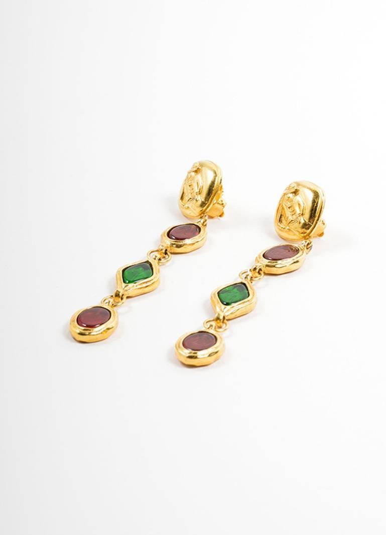 Vintage earrings. Gold tone metal. Diamond shaped base with carved Coco Chanel figure. Three tier drop with red & green gripoix stones. Clip on backs.

Condition details: Pre-owned. This item is in great condition, particularly for a vintage